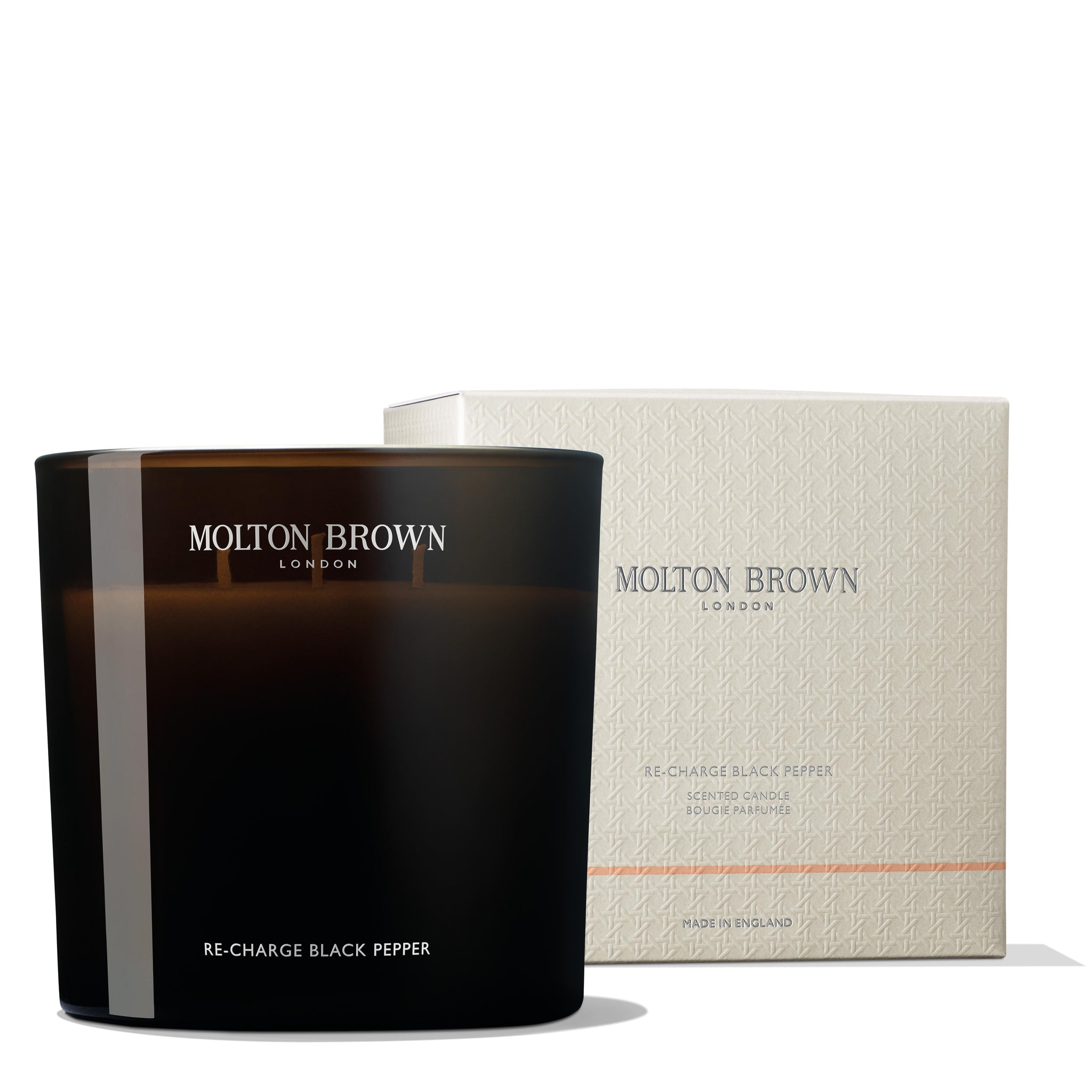 The Re-charge Black Pepper Luxury Kaars 600g by MoltonBrown Nederlands is displayed before a matching pale, textured box—both elegantly set against a white background to elevate any woonkamer.