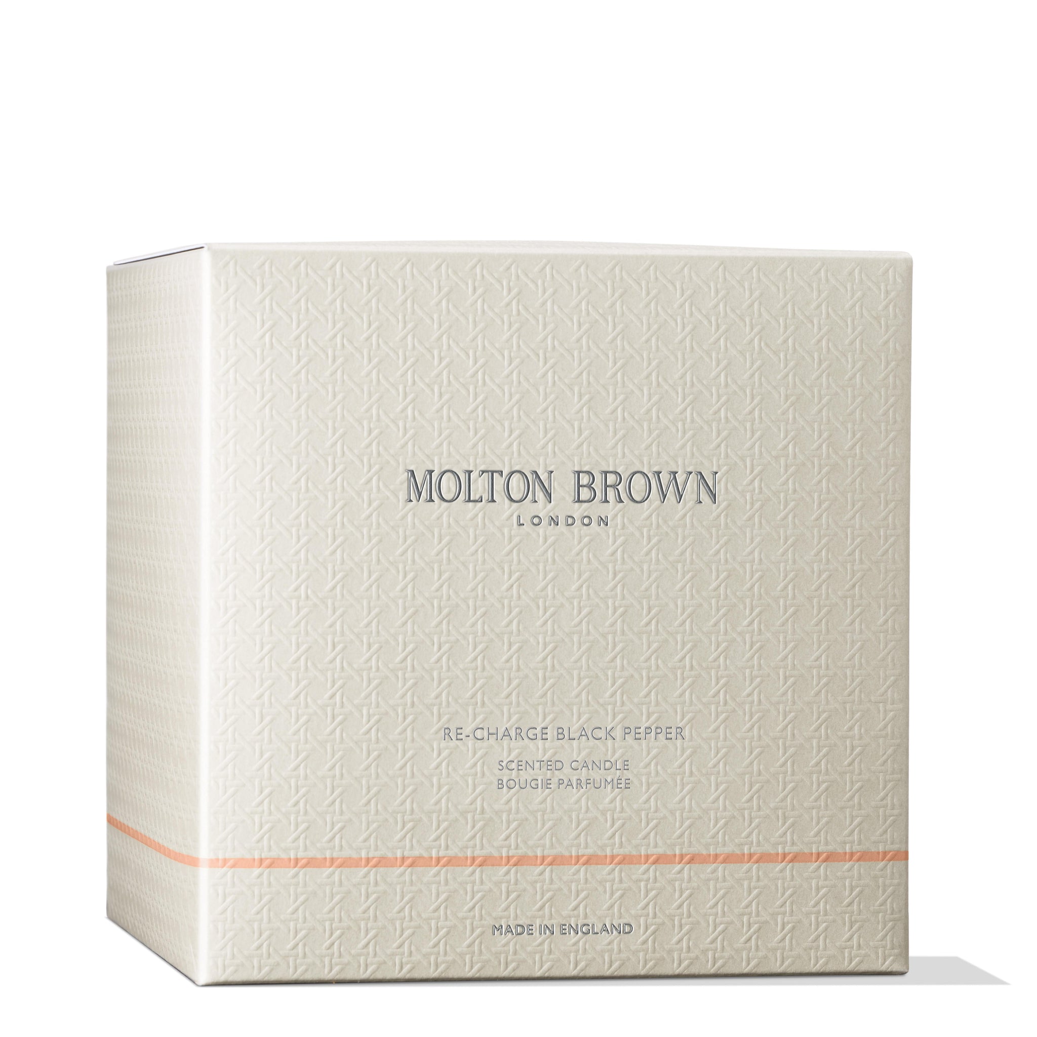 A cream-colored box with a subtle geometric pattern and the text MoltonBrown Nederlands Re-charge Black Pepper Luxury Kaars 600g on the front. This luxe kaars adds elegance to je woonkamer. The box is closed and has a minimal design.