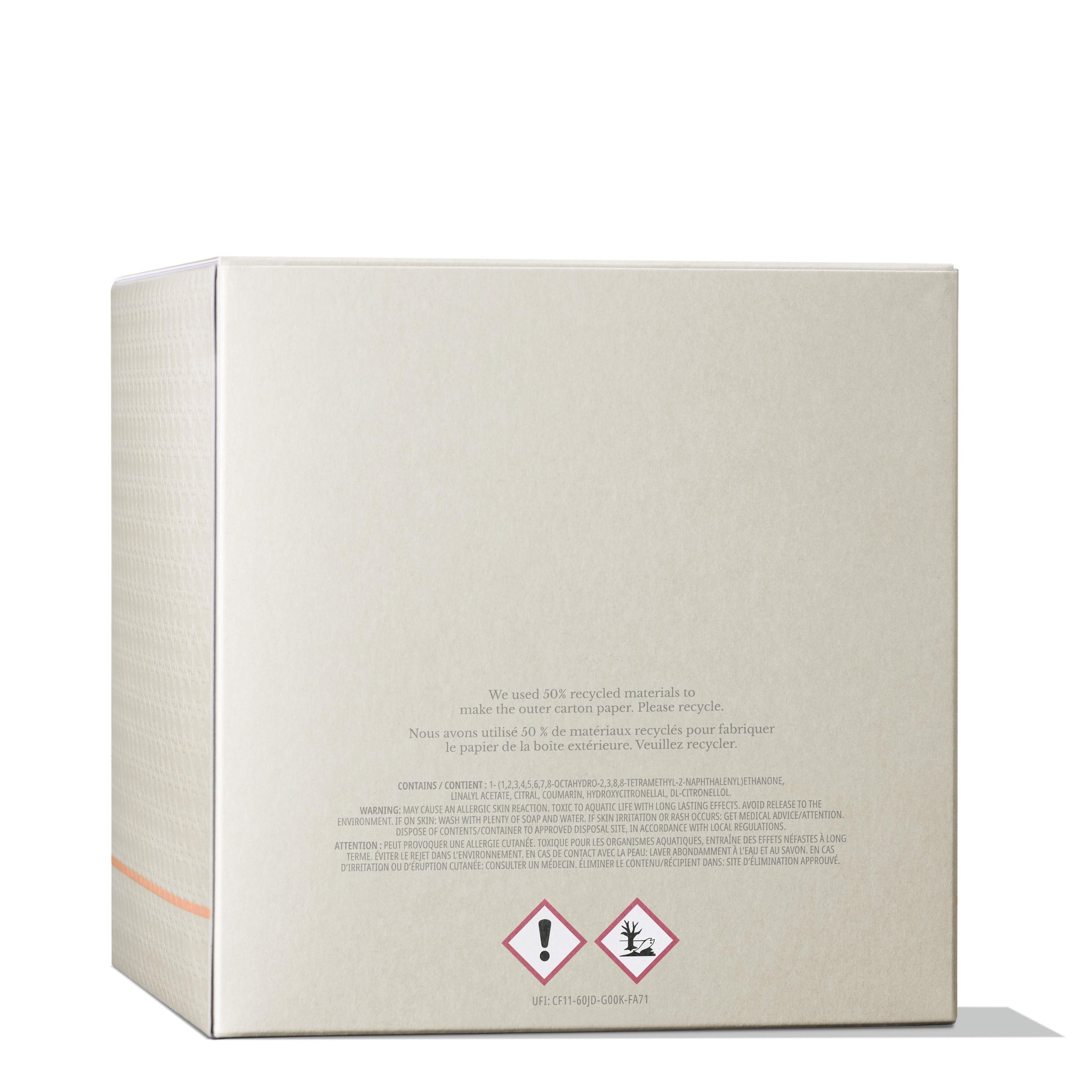 A beige cardboard box with a safety warning label at the bottom, showing hazard symbols. English and French text state it's made from 100% recycled materials. Perfect for storing your MoltonBrown Nederlands Re-charge Black Pepper Luxury Kaars 600g in the woonkamer.