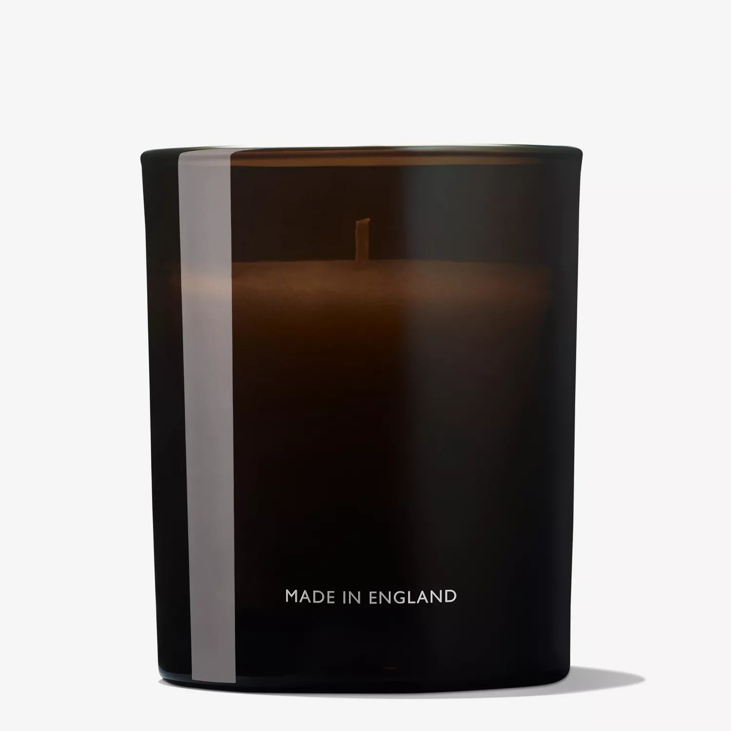 A dark brown glass MoltonBrown Nederlands Mesmerising Oudh Accord & Gold Signature Kaars 190g with a single wick is shown unused, against a plain white background. The front displays "MADE IN ENGLAND.
