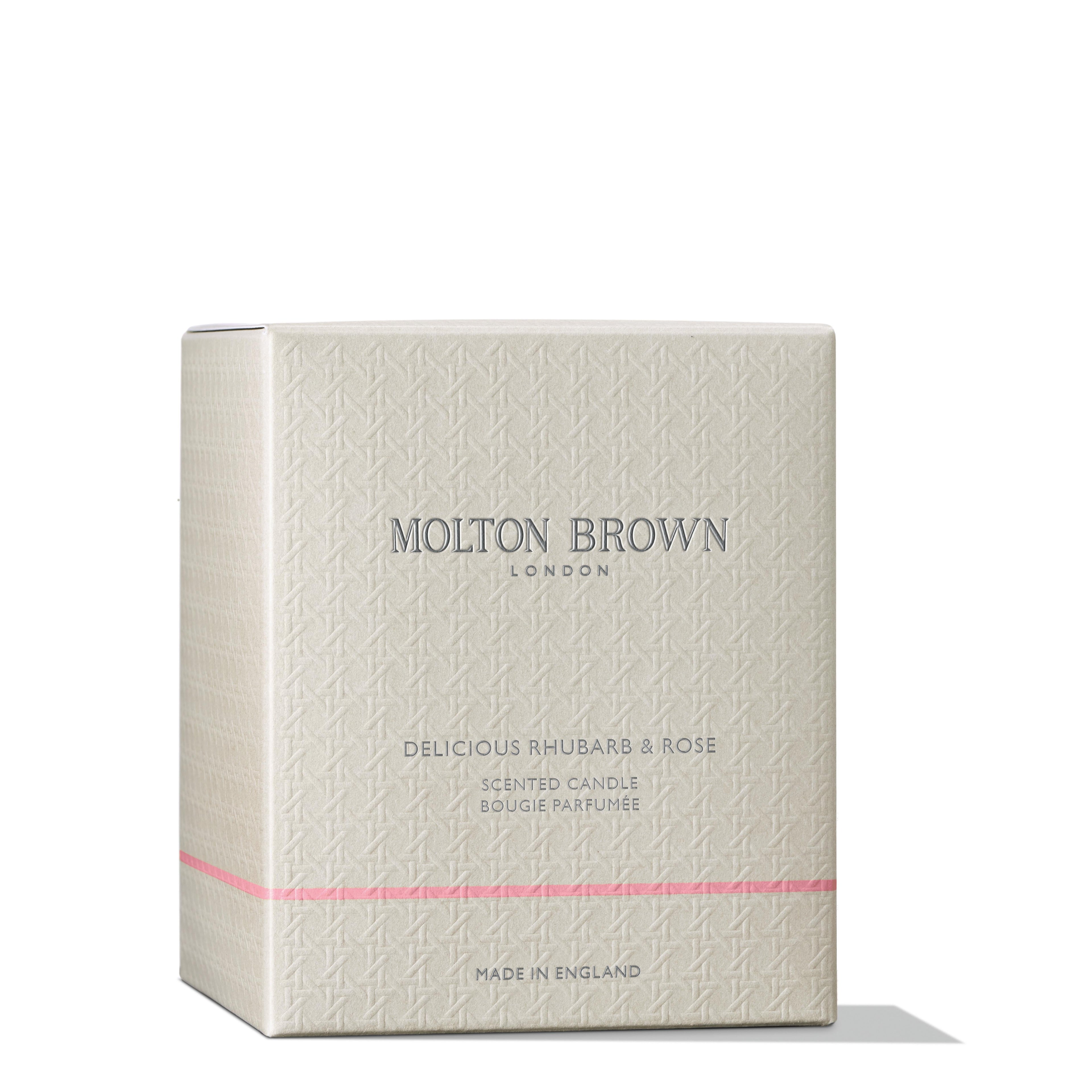 A beige box with a subtle texture and thin pink stripe, labeled MoltonBrown Nederlands. It reads Delicious Rhubarb & Rose Signature Kaars 190g, also as Rabarber & Roos geurkaars. Marked Made in England.