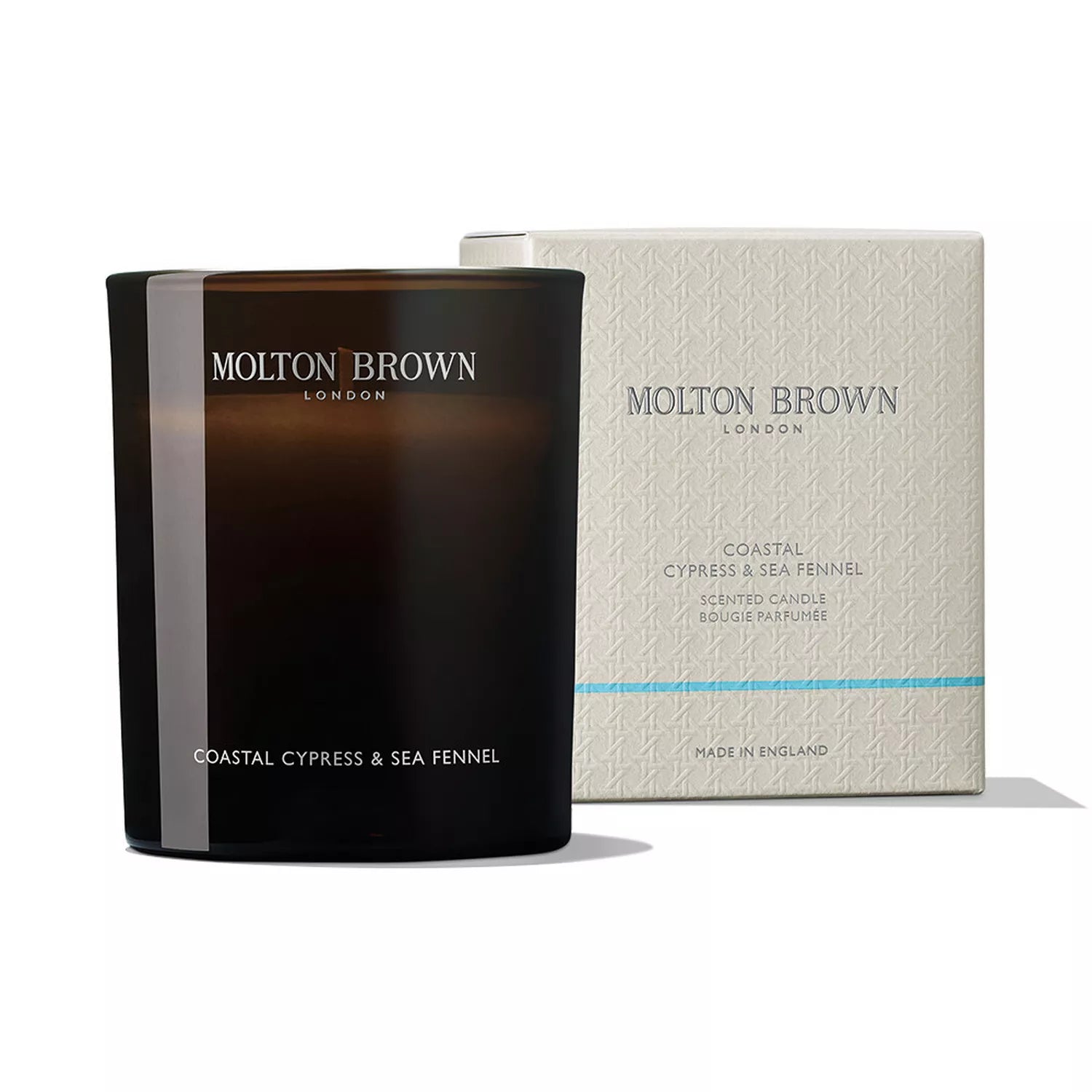 A MoltonBrown Nederlands Coastal Cypress & Sea Fennel Signature Kaars 190g in a dark glass jar is displayed beside its light-colored, patterned box, both clearly showing the brand and product name.