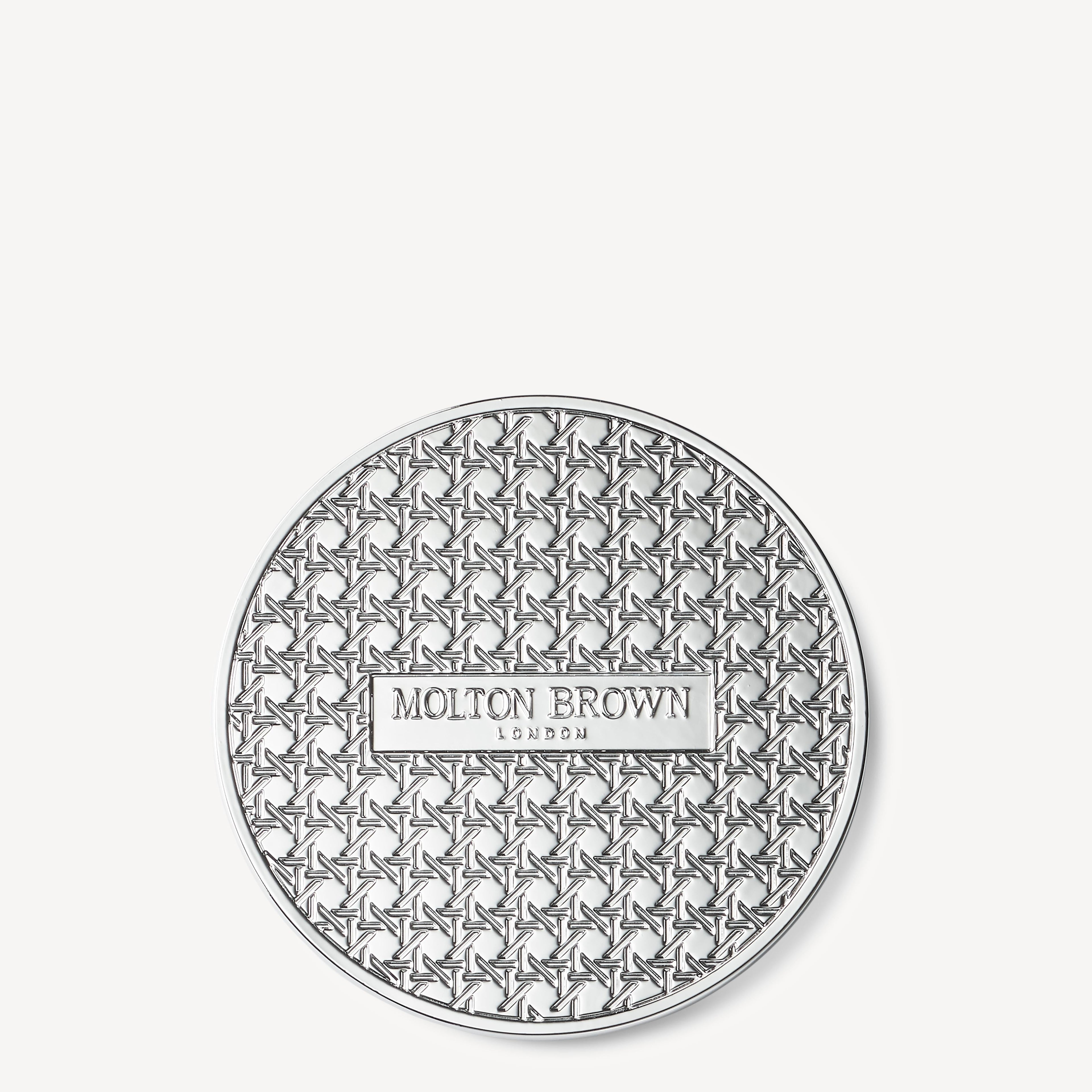 A round, silver-toned MoltonBrown Nederlands Signature Kaars Lid 98g with a textured geometric star design—perfect for stylishly covering your scented candle to behouden geur and keep it protected.