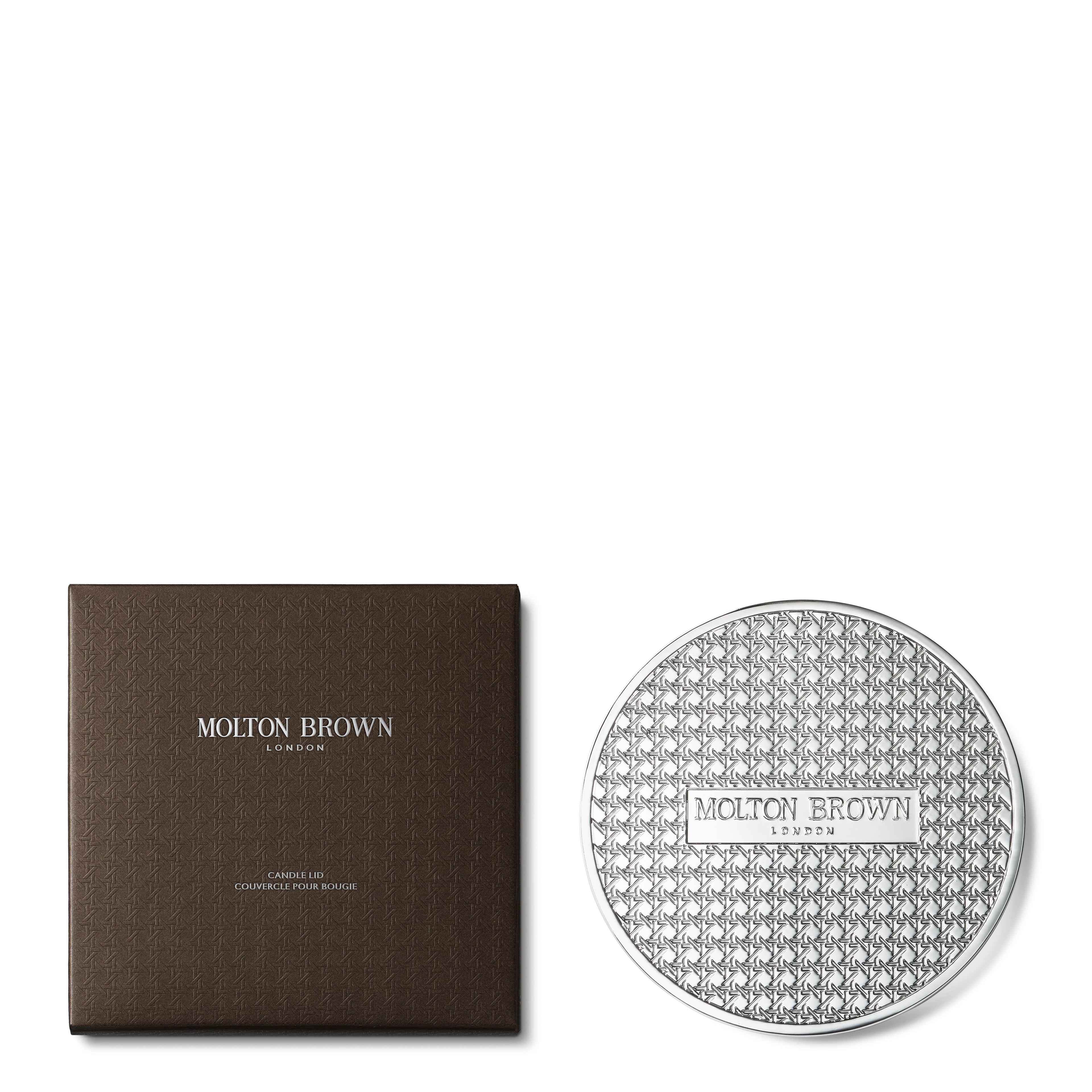 A square brown MoltonBrown Nederlands box and a round, silver-patterned Luxury Kaars Lid 154g accessory, both with the brand label, are set against a white background.