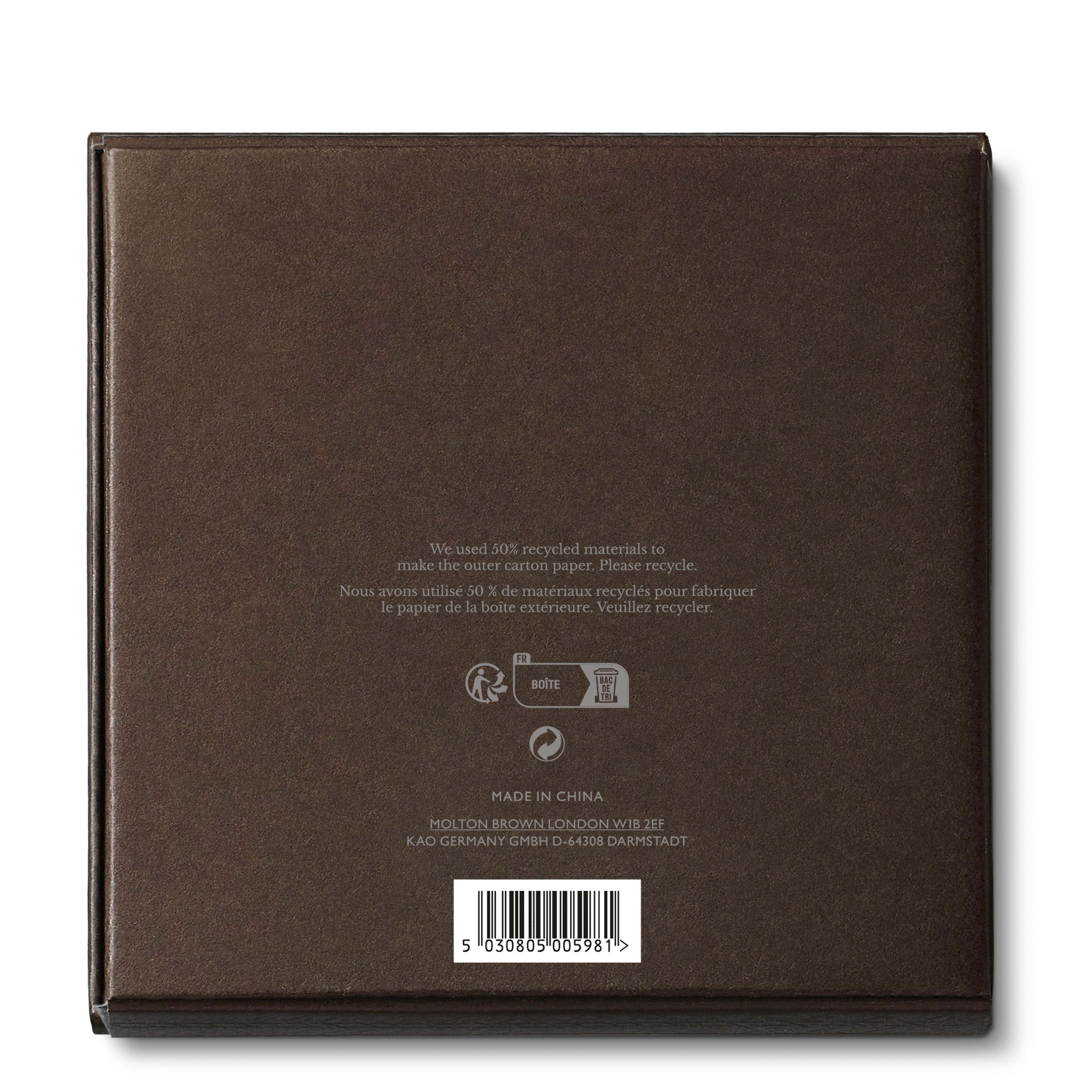 A brown square cardboard box from MoltonBrown Nederlands, for the Luxury Kaars Lid 154g. Back shows small white text: made from 50% recycled materials, recycling symbols, manufacturer info (Made in China), and a barcode—perfect for storing kaarsaccessoire like a lontknipper.