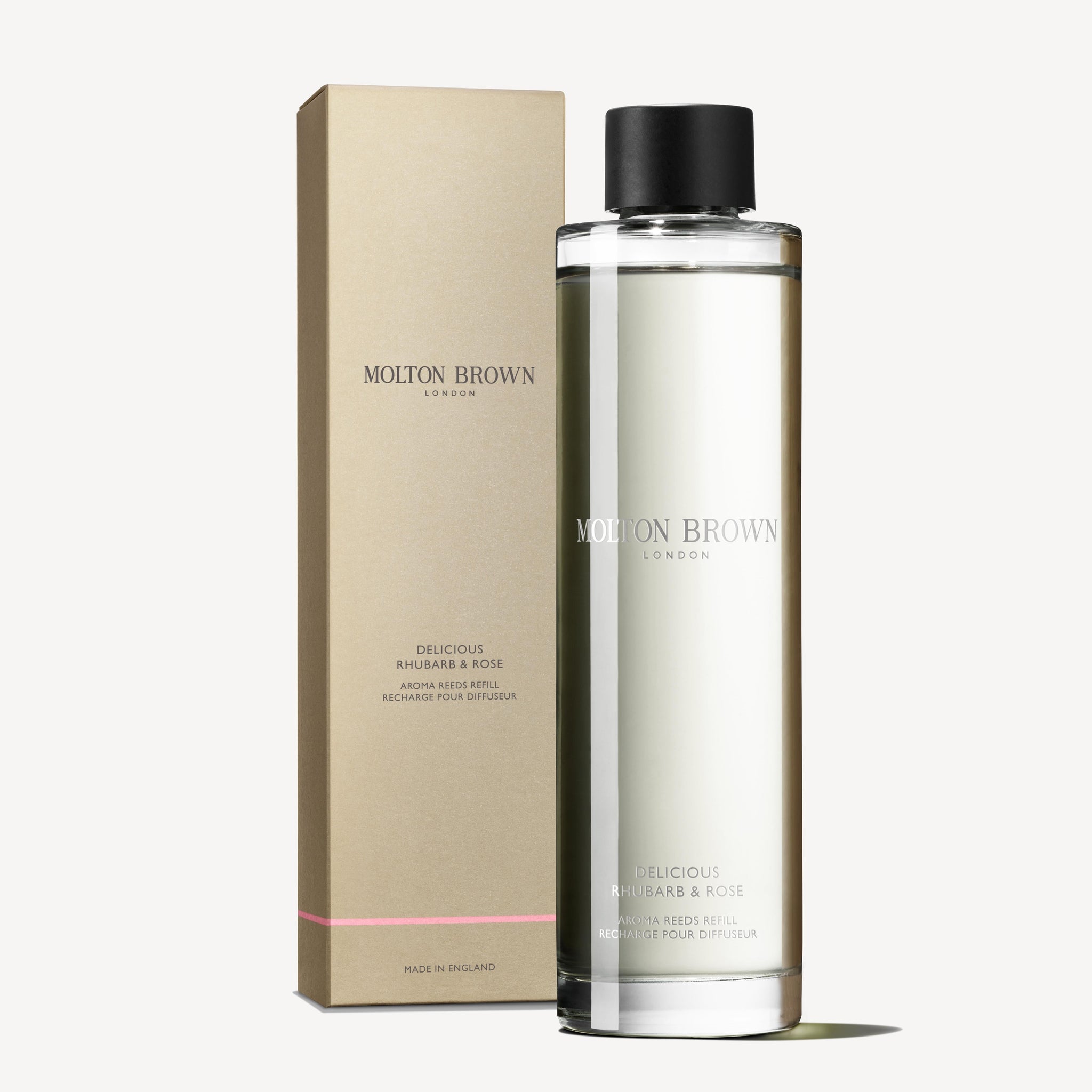 A clear bottle labeled MoltonBrown Nederlands Delicious Rhubarb & Rose Geurstokjes Navulling 150ml stands before a matching beige and pink box on a white background.