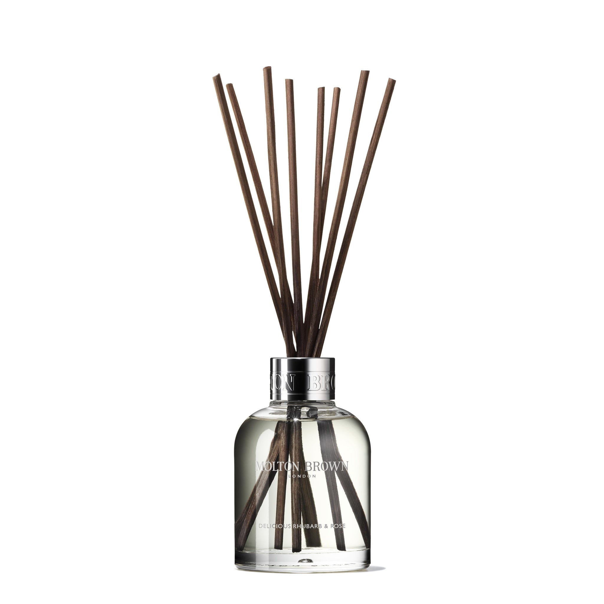 A MoltonBrown Nederlands Delicious Rhubarb & Rose Geurstokjes Navulling 150ml clear glass bottle sits against a white background, filled with scented liquid and several dark brown sticks fanned out from the top.
