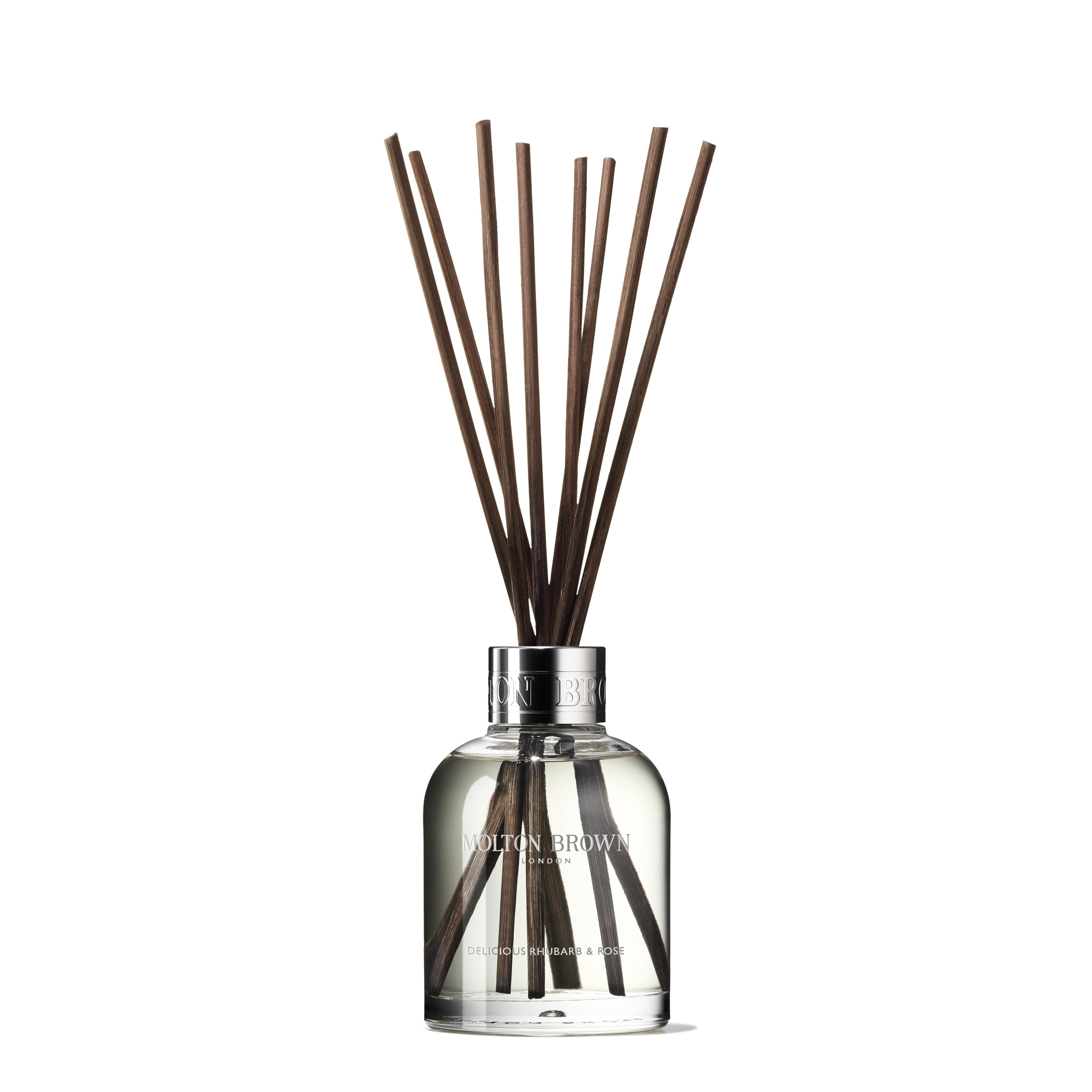 A MoltonBrown Nederlands Delicious Rhubarb & Rose Geurstokjes Navulling 150ml clear glass bottle sits against a white background, filled with scented liquid and several dark brown sticks fanned out from the top.