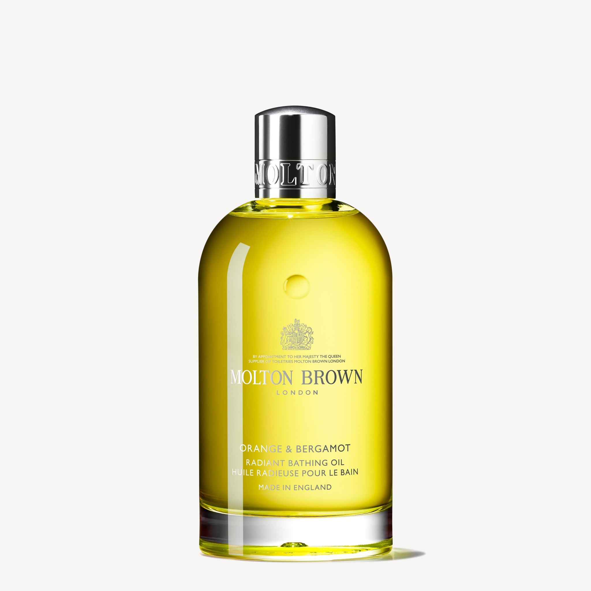 A clear bottle of MoltonBrown Nederlands Orange & Bergamot Radiant Bathing Oil 200ml, featuring yellow liquid and a shiny silver cap, displayed against a plain white background.
