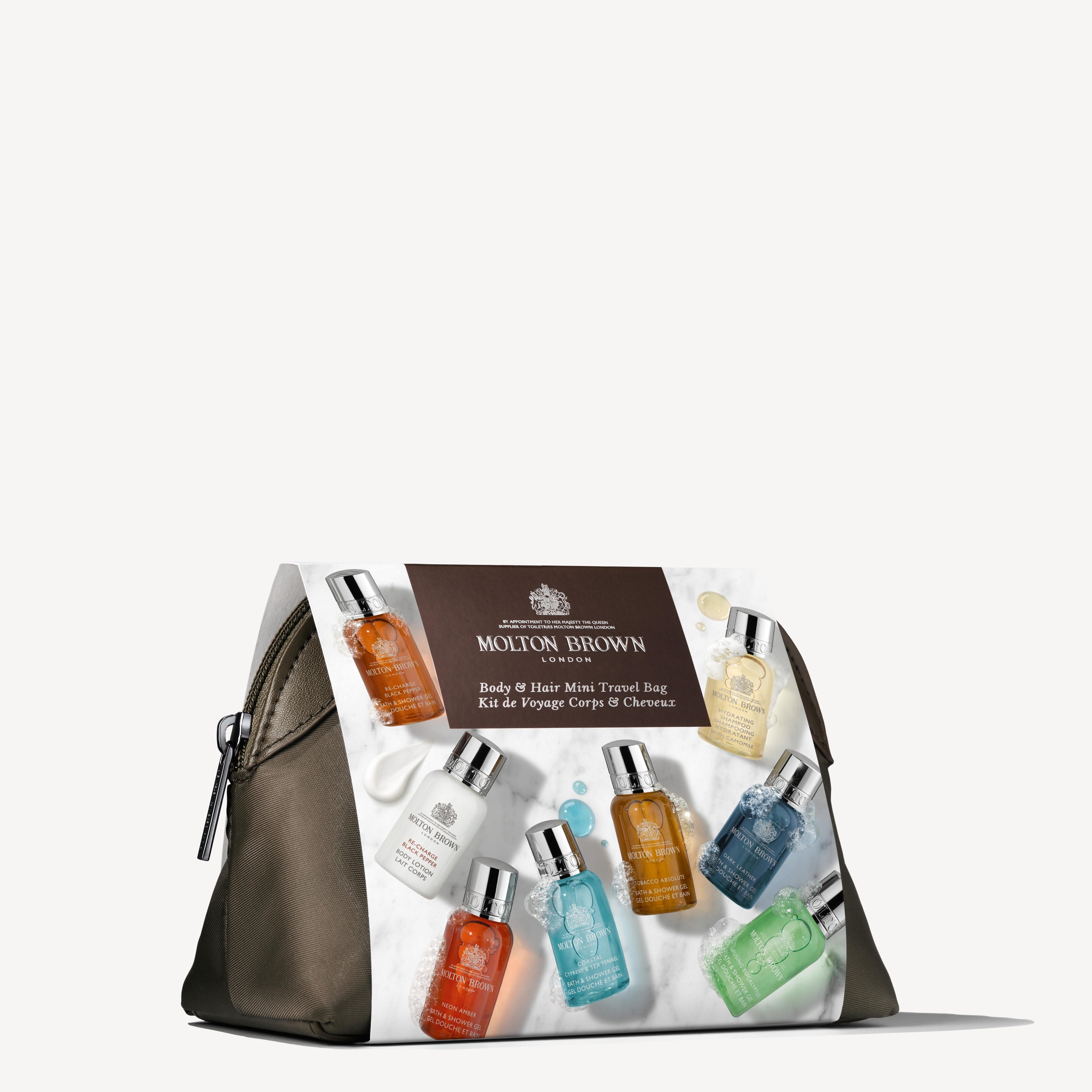 The Classic Explorer Body & Hair Mini Reistas from MoltonBrown Nederlands features a zippered bag with the iconic label, filled with colorful mini body and hair care bottles, all displayed neatly on a white background.
