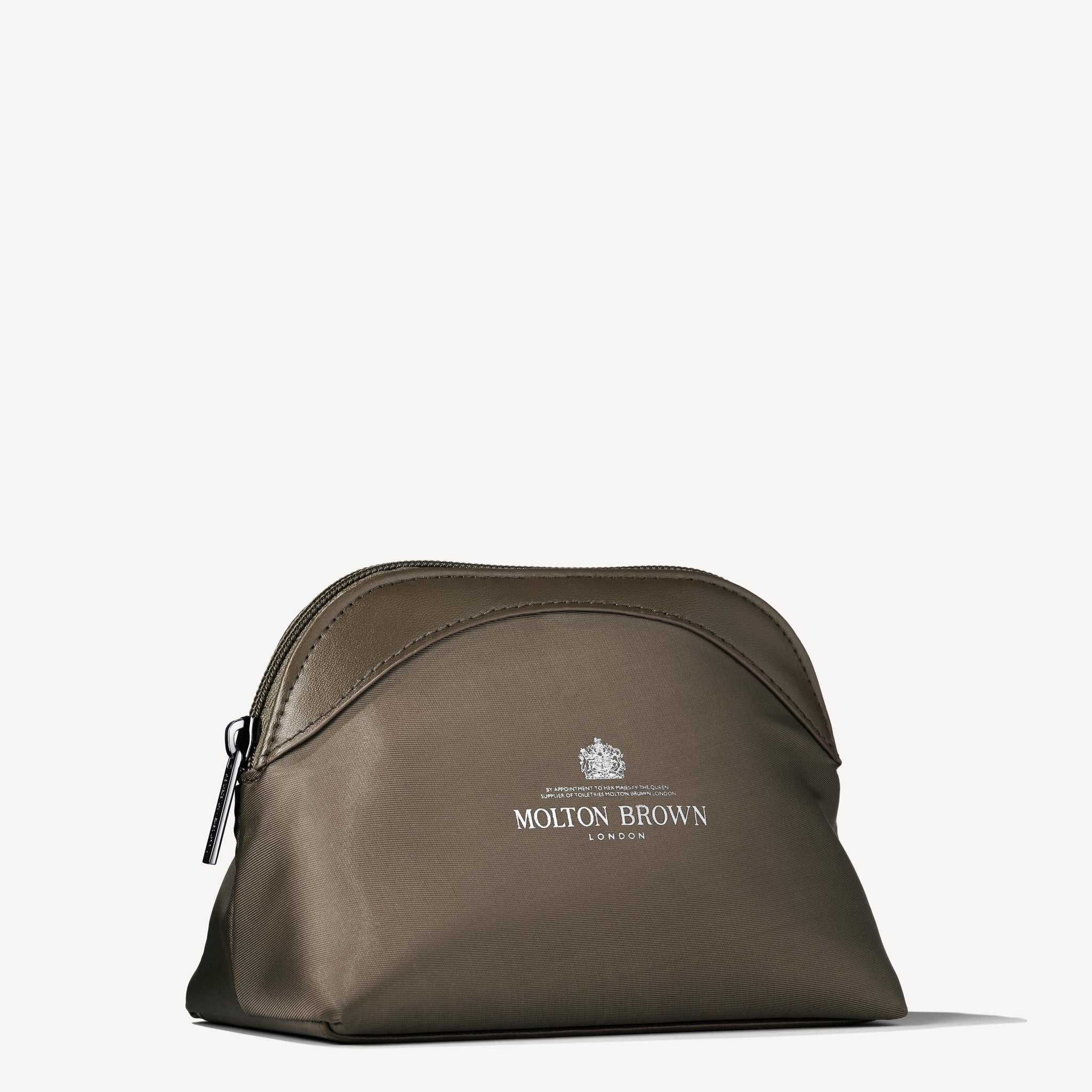 The Classic Explorer Body & Hair Mini Reistas by MoltonBrown Nederlands is a brown zippered bag with the Molton Brown London logo in white on the front, ideal for essentials and suitable for convenient reisformaten.