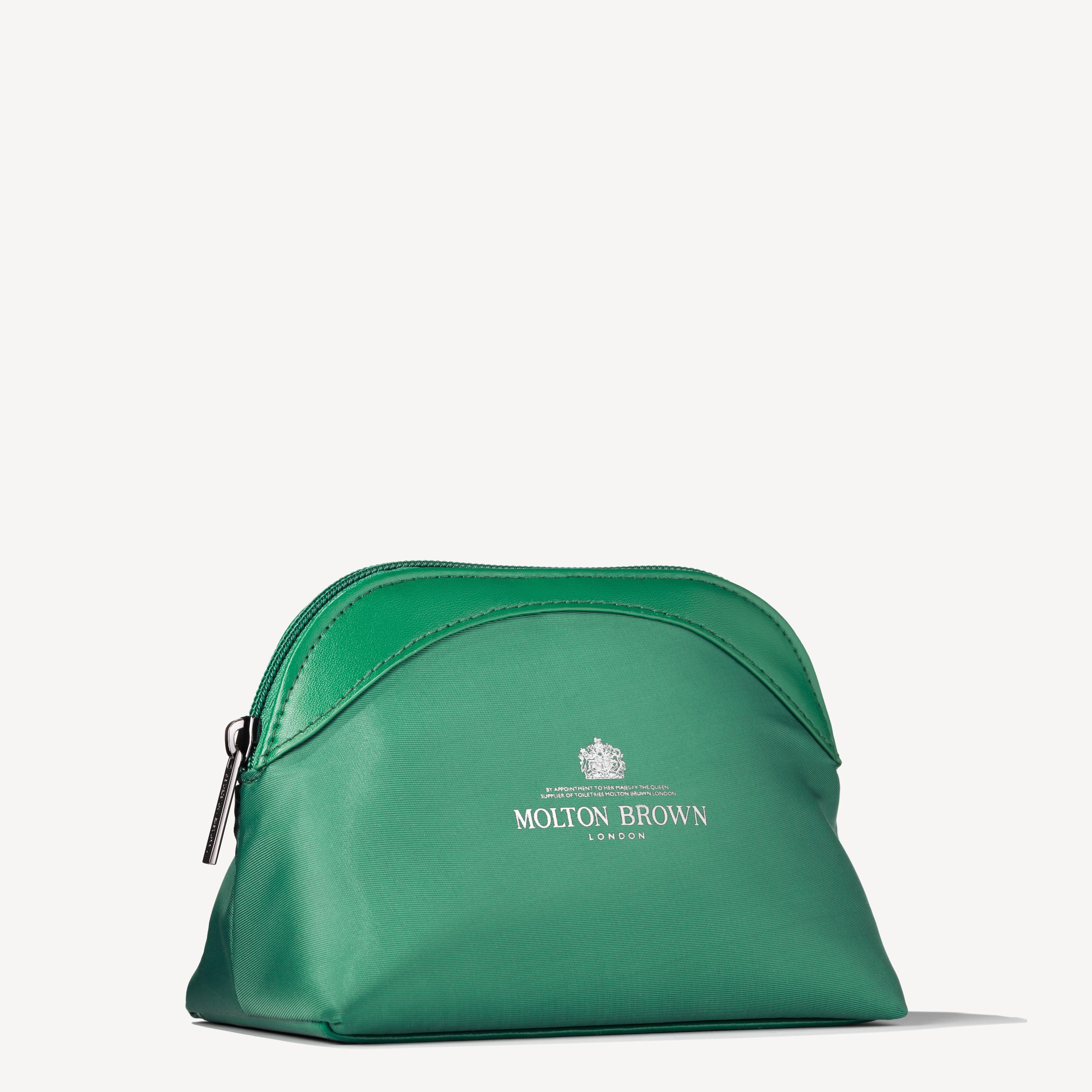 The Elegant Escapist Body & Hair Mini Reistas by MoltonBrown Nederlands is a green zippered pouch with a shiny finish and white logo, ideal for your reisformaat essentials—shown here on a plain white background.