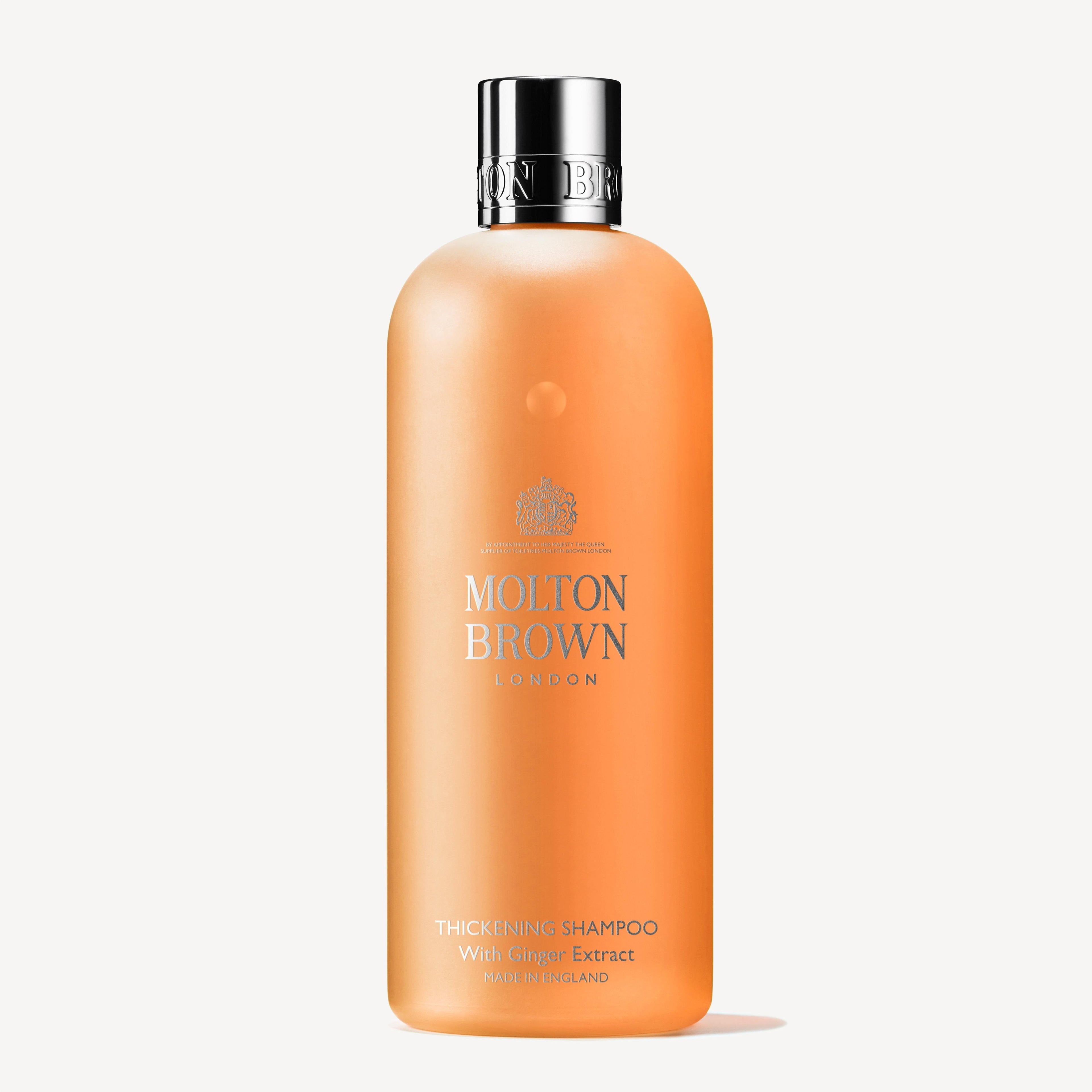 A 300ml bottle of MoltonBrown Nederlands Thickening Shampoo With Ginger Extract, with an orange translucent body, silver cap, and silver text—vegan and perfect for volume voor fijn haar.
