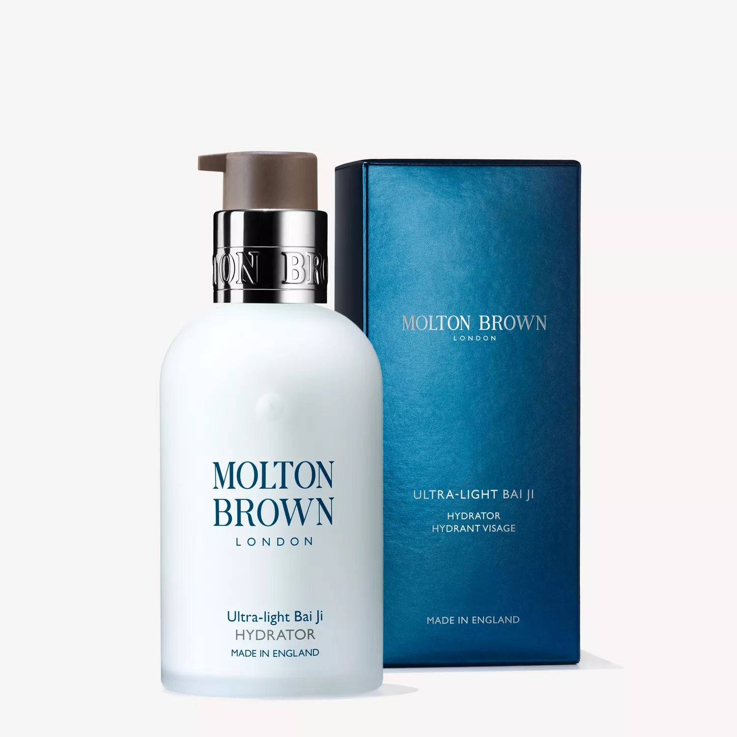 A white pump bottle of MoltonBrown Nederlands Ultra-light Bai Ji Hydrator 100ml stands before its blue box, both showing brand and product info. Perfect voor dagelijks gebruik. The background is plain white.