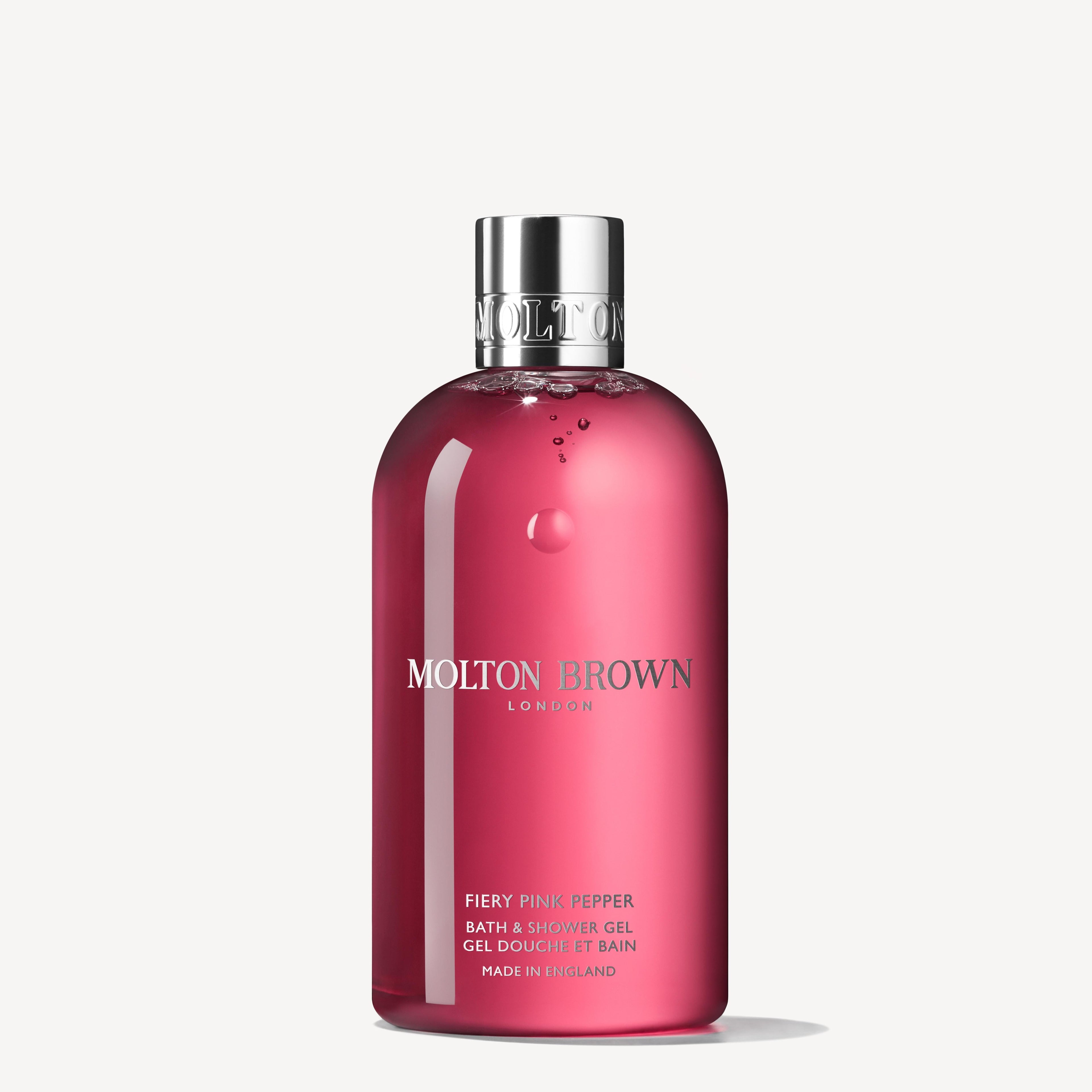 A 300ml bottle of MoltonBrown Nederlands Fiery Pink Pepper Bad- & Douchegel, featuring bright pink liquid in a clear plastic container with a silver cap and white label text.