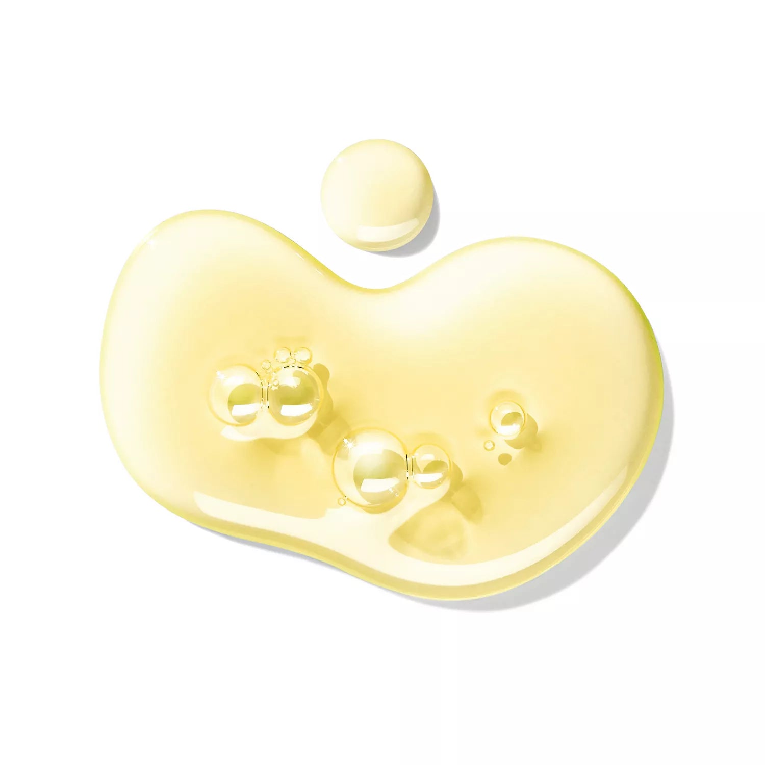 A close-up of a translucent, yellow-tinted drop with small bubbles, reminiscent of MoltonBrown Nederlands Fiery Pink Pepper Perfumed Soap 150g, set against a white background.