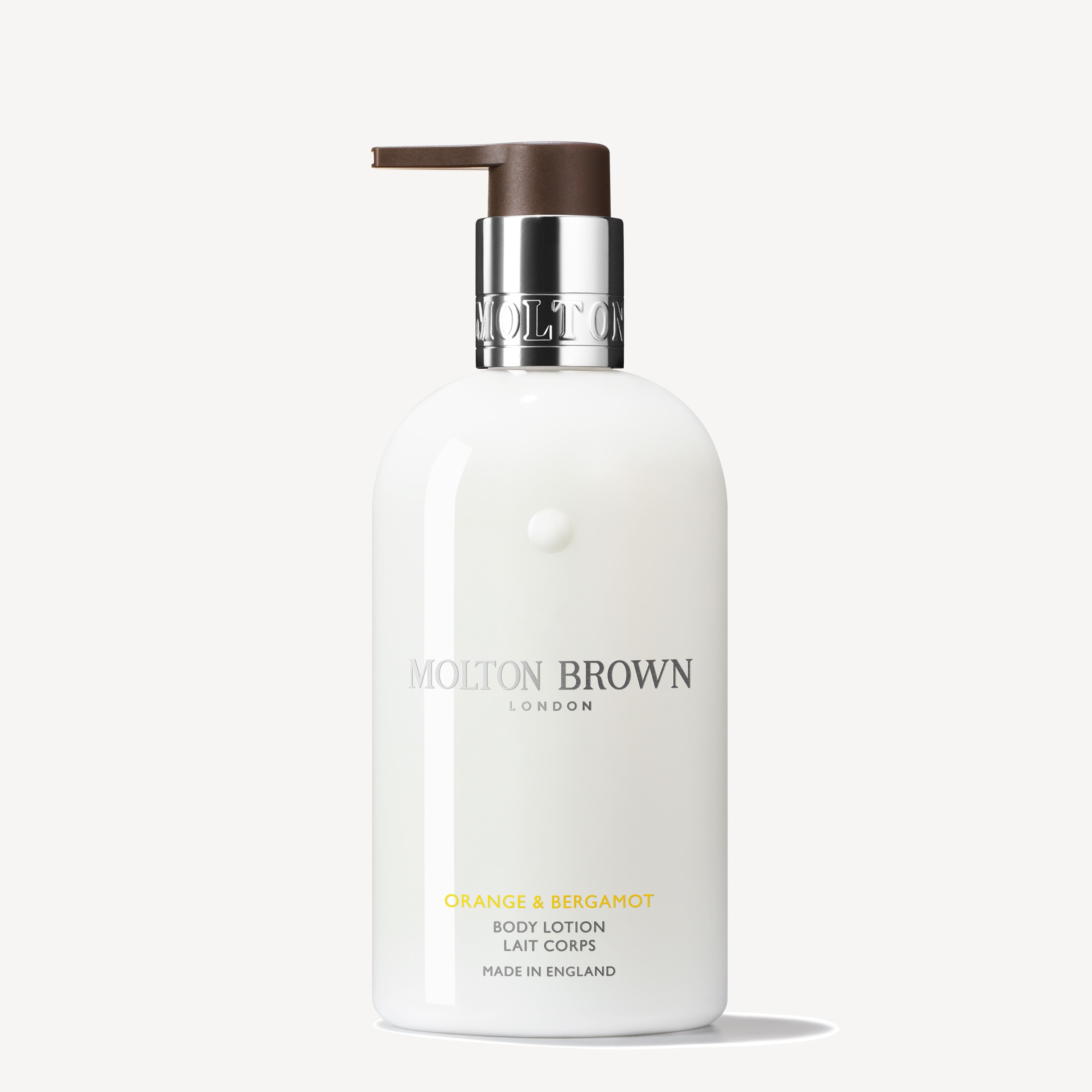 A 300ml MoltonBrown Nederlands Orange & Bergamot Bodylotion bottle with a silver collar and brown pump stands upright on a plain light background, infused with uplifting sinaasappel and neroli notes.