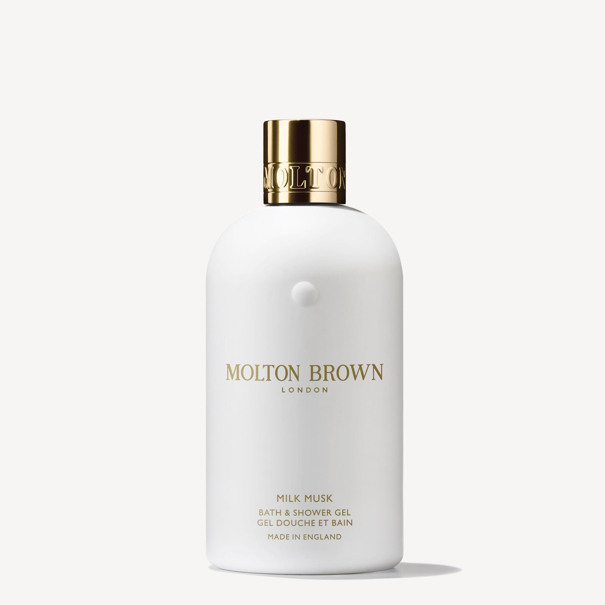A white 300ml bottle of MoltonBrown Nederlands Milk Musk Bad- & Douchegel with a gold cap and gold text stands upright on a white background, featuring a sensual musk fragrance.