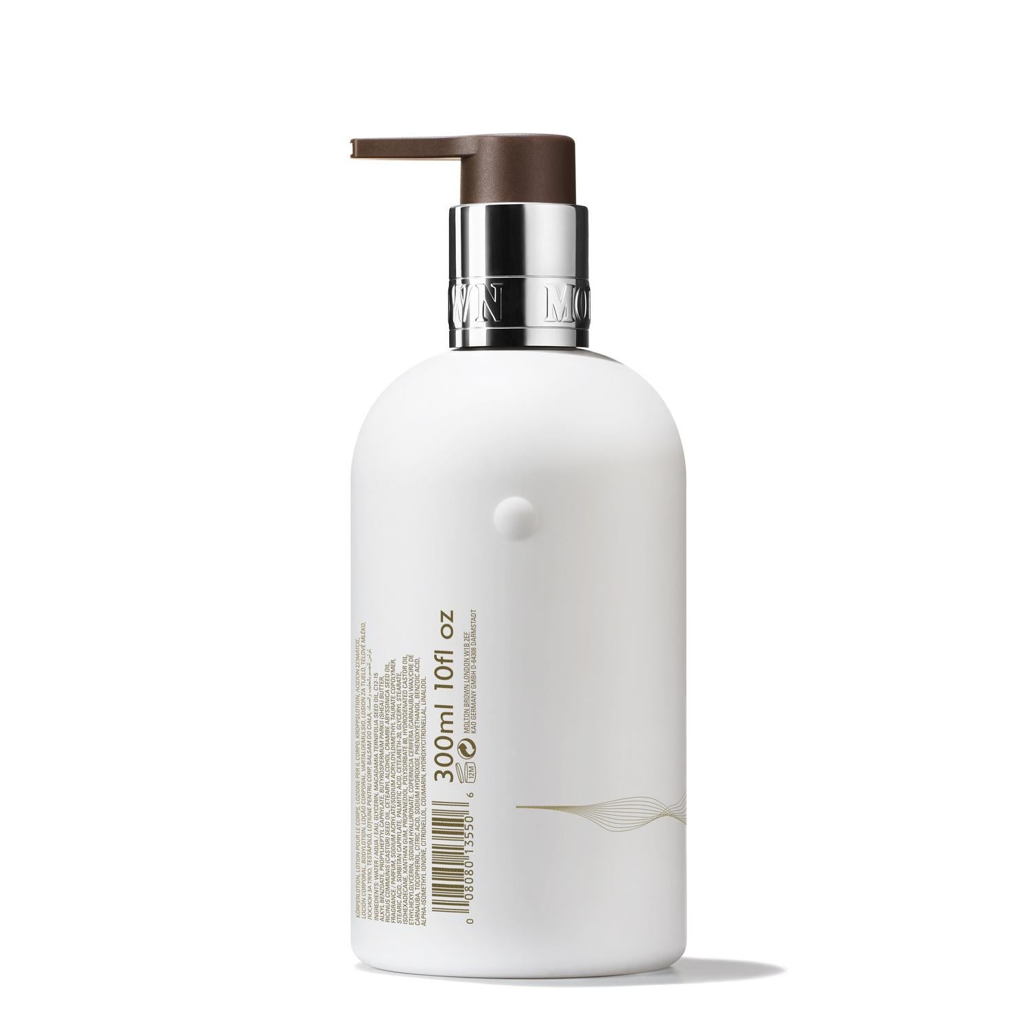 The MoltonBrown Nederlands Milk Musk Bodylotion 300ml comes in a white pump bottle with a silver collar, brown dispenser, and minimalist gold details. It hydrates the skin and provides luxurious care with a subtle peer musk scent.