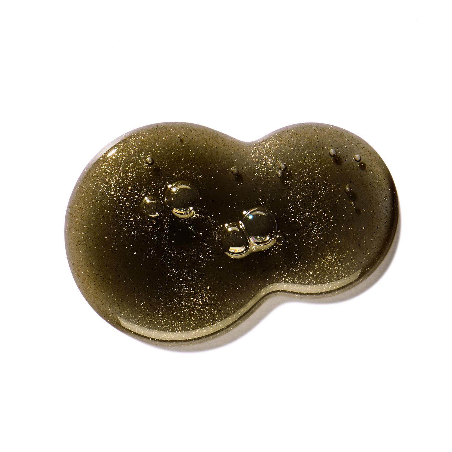 A smooth, translucent blob of MoltonBrown Nederlands Labdanum Dusk Bad- & Douchegel 300ml with shimmery bubbles inside, shaped like an abstract peanut, is shown on a white background.