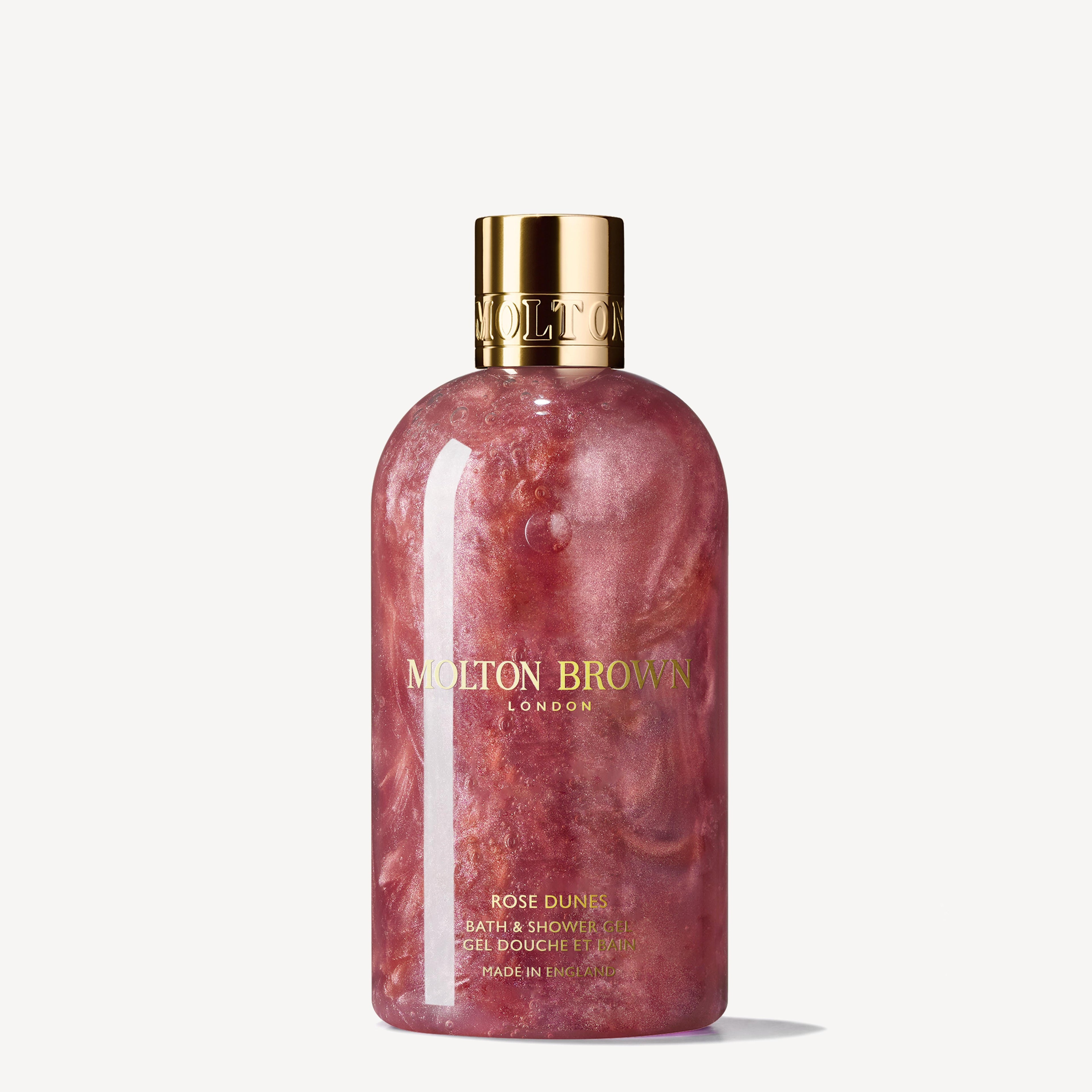 Experience the Rose Dunes Bad- & Douchegel 300ml from MoltonBrown Nederlands—infused with Bulgaarse roos, oud hout Sulawesi, and a touch of pink glitter for a sparkling, amberachtig-rozen vibe in your shower routine.