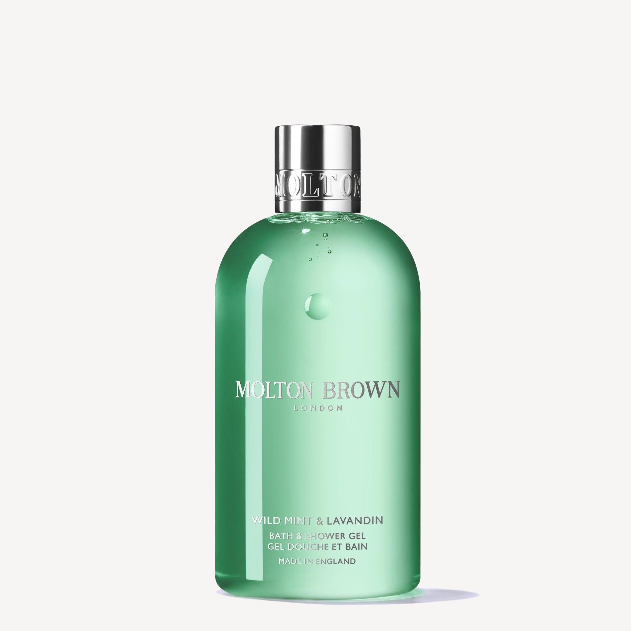 A 300ml green bottle of MoltonBrown Nederlands Wild Mint & Lavandin Bad- & Douchegel, topped with a silver cap, is displayed against a plain white background.