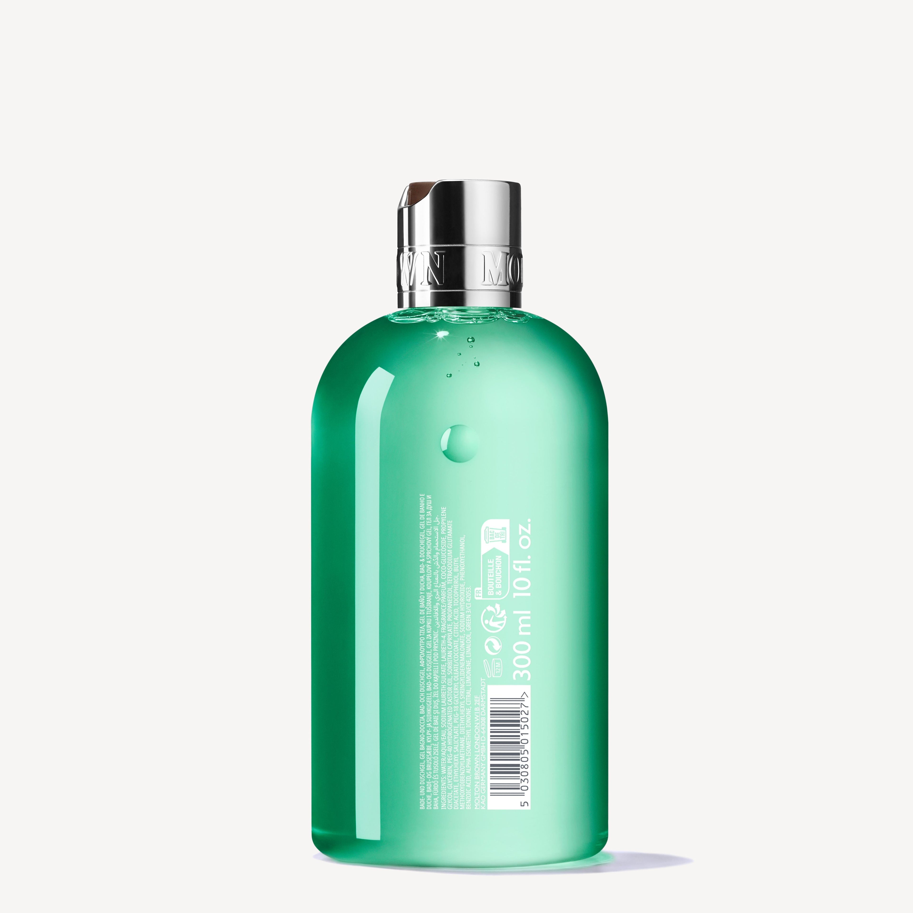 A green translucent 300ml bottle of MoltonBrown Nederlands Wild Mint & Lavandin Bad- & Douchegel with a silver cap stands upright on a white background. The back label displays product info and a barcode.