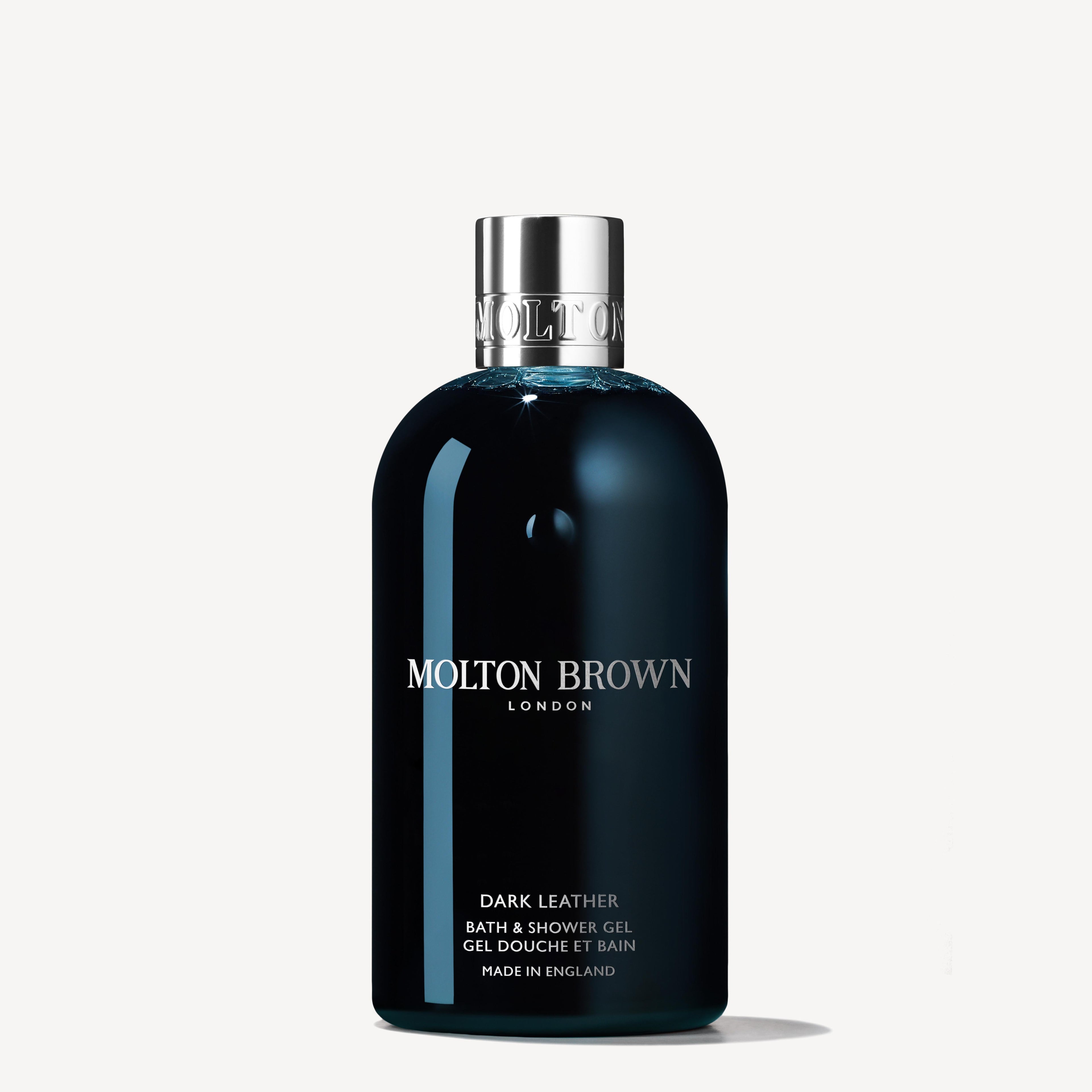 A 300ml MoltonBrown Nederlands Dark Leather Bad- & Douchegel in a dark blue bottle with a silver cap is shown on a white background. The white label suggests its rokerig leer en mannelijke geur.