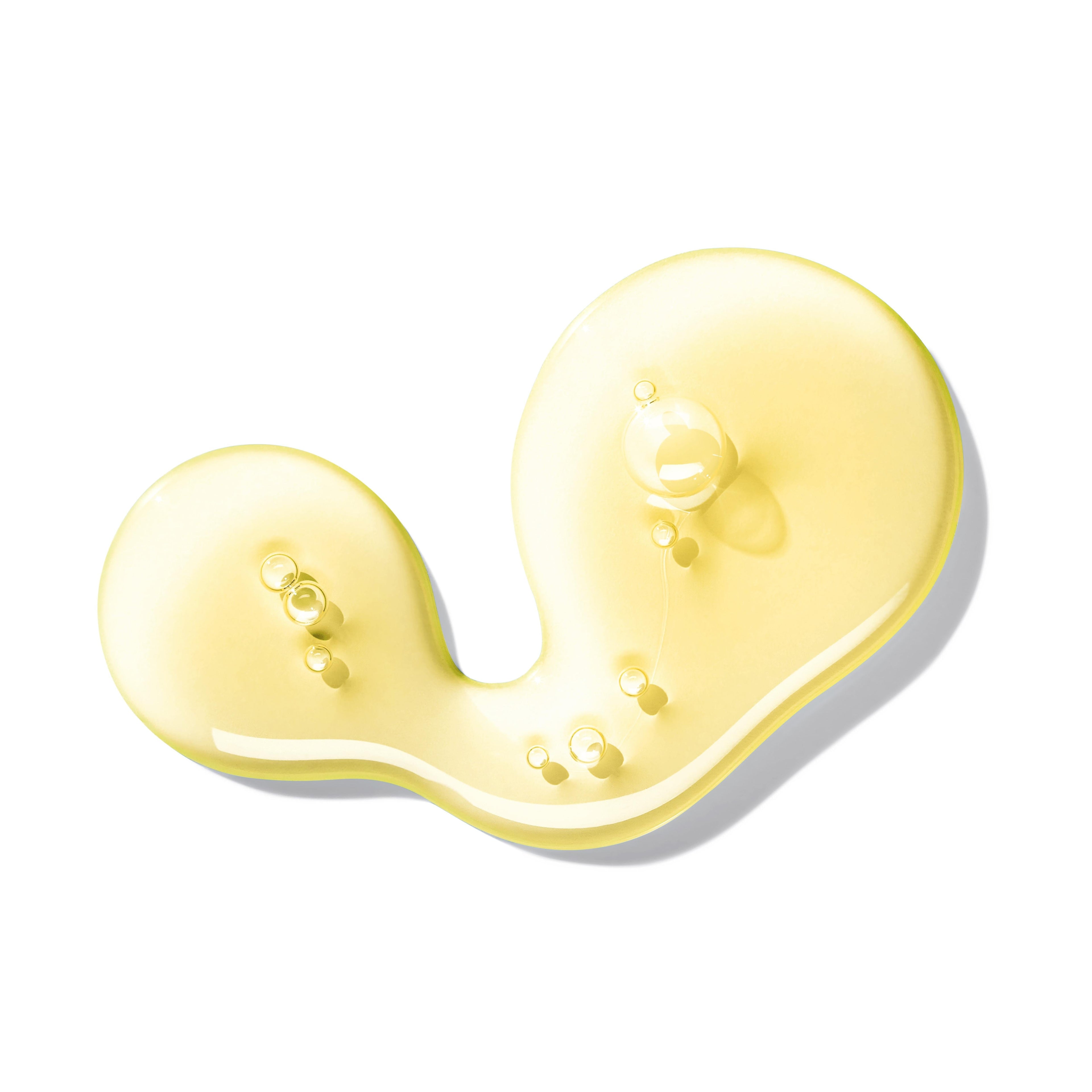 A shiny, translucent yellow liquid with small bubbles forms an abstract curve on white, evoking the fresh scent of Orange & Bergamot Vloeibare Handzeep 300ml from MoltonBrown Nederlands.
