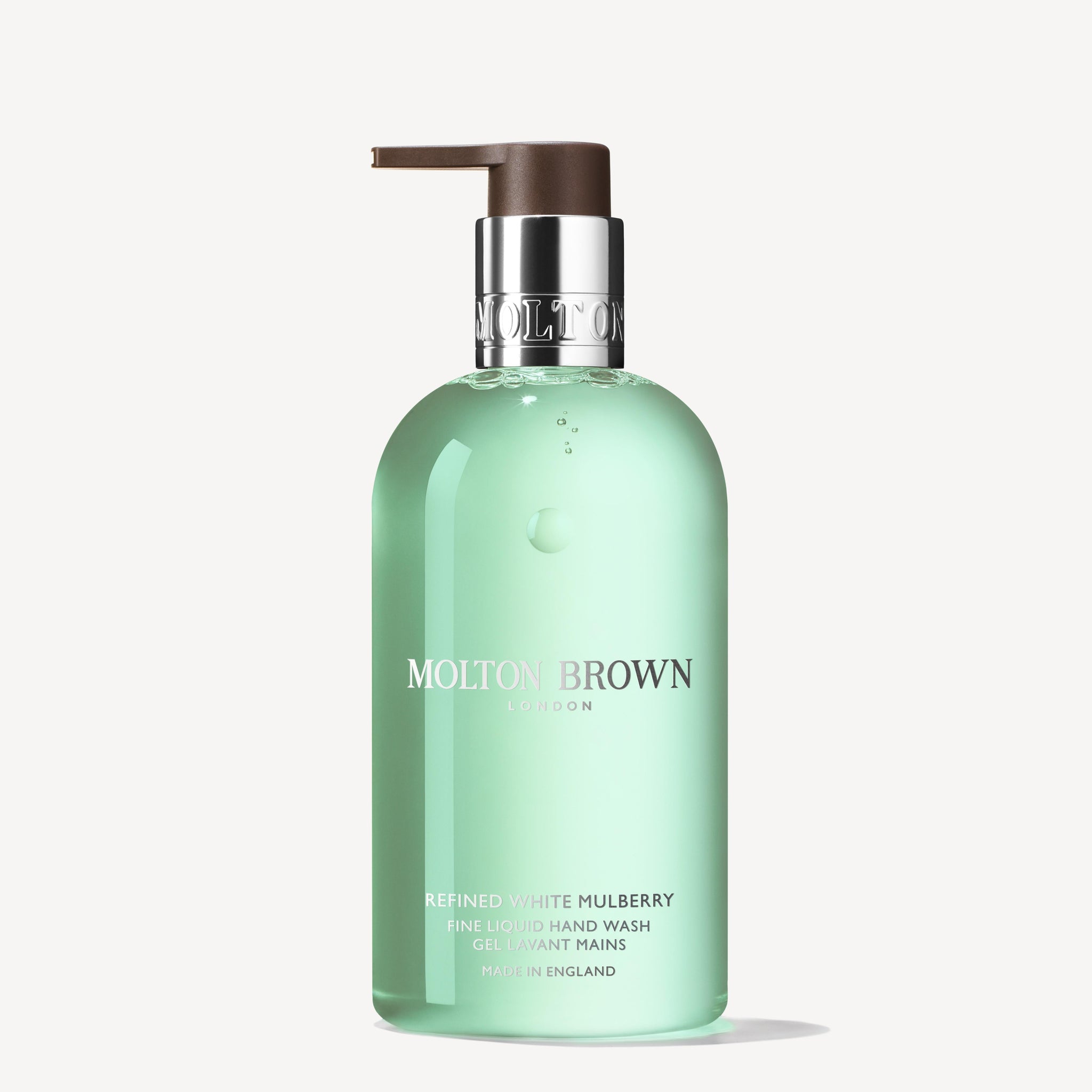 A 300ml clear green bottle of MoltonBrown Nederlands Refined White Mulberry Vloeibare Handzeep, with a brown pump and silver collar, shown on a white background. Features hints of witte moerbei and delicate jasmijn.