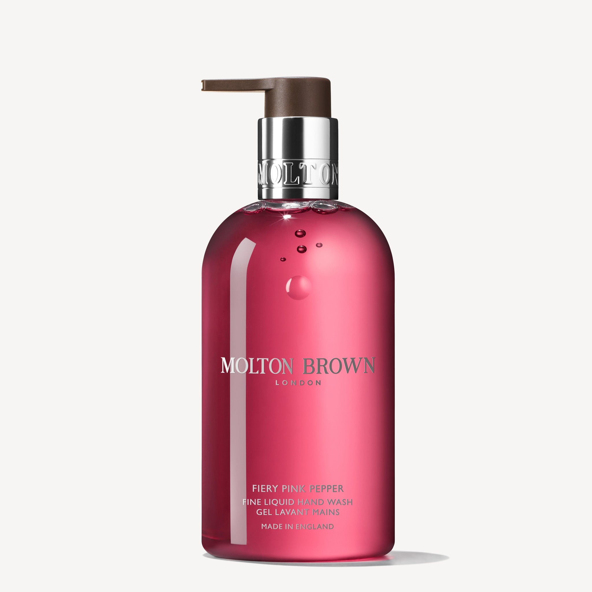 A clear pink bottle of MoltonBrown Nederlands Fiery Pink Pepper Vloeibare Handzeep 300ml with pump dispenser, silver and white label text, featuring roze peper and patchouli notes.