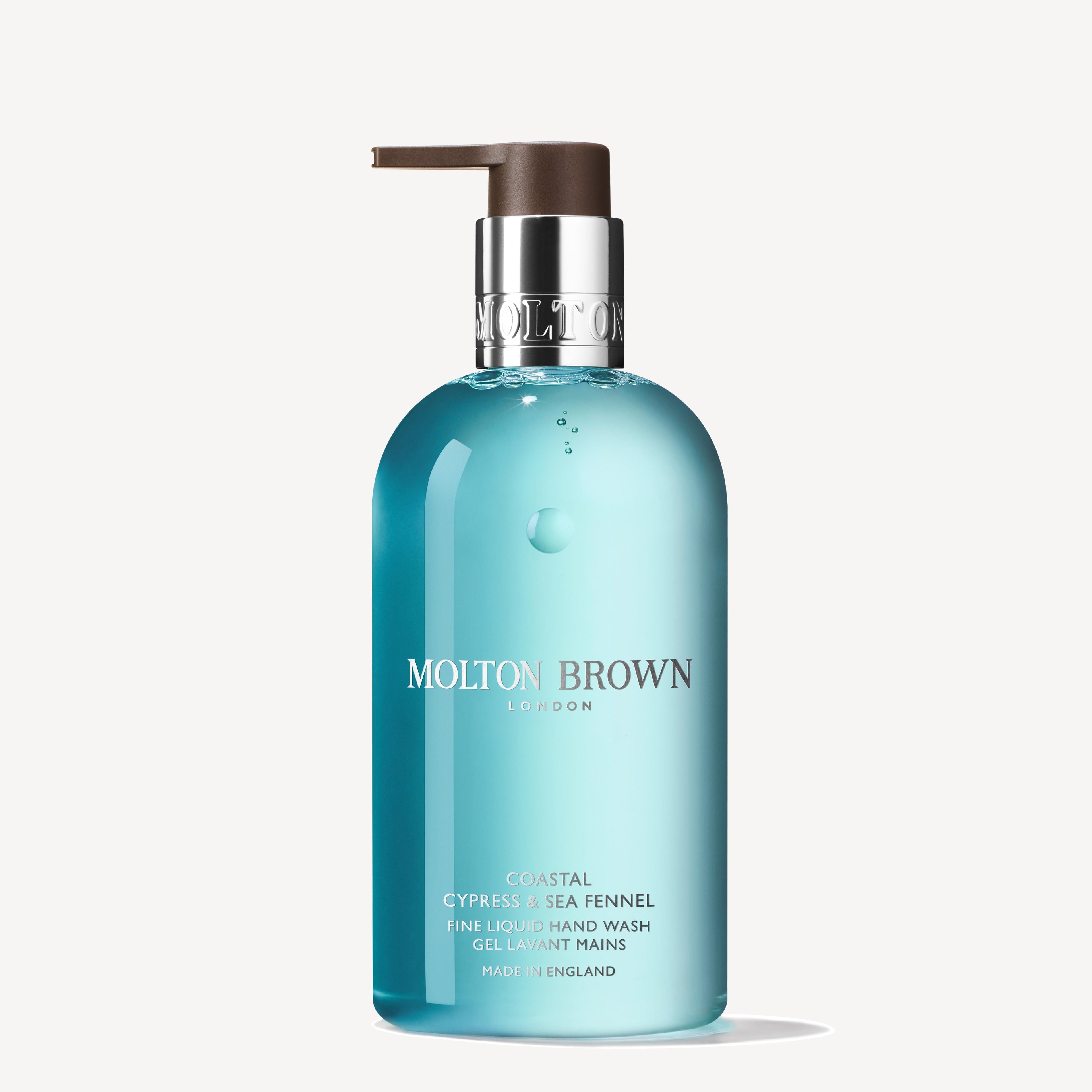 A turquoise bottle of MoltonBrown Nederlands Coastal Cypress & Sea Fennel Vloeibare Handzeep 300ml with a dark pump and white-silver label, inspired by maritieme accenten and zeebries, set against a plain white background.
