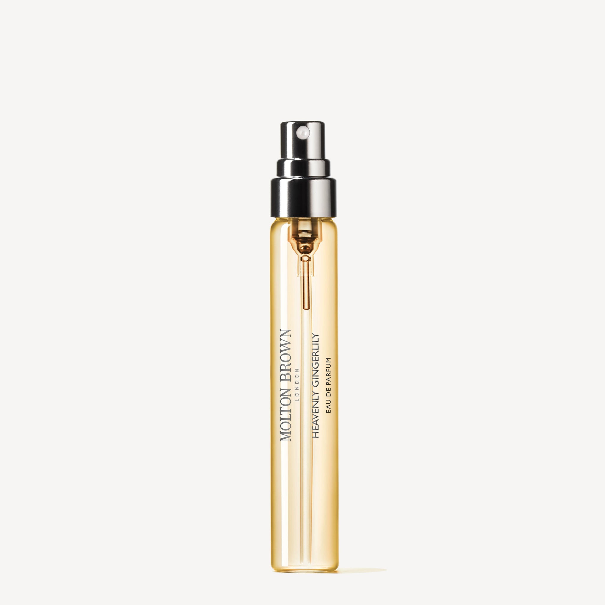 A clear glass spray bottle with light golden liquid, labeled "MoltonBrown Nederlands Heavenly Gingerlily Eau de Parfum Reiskoffer Navulling 7.5ml," featuring jasmine notes, displayed against a white background.