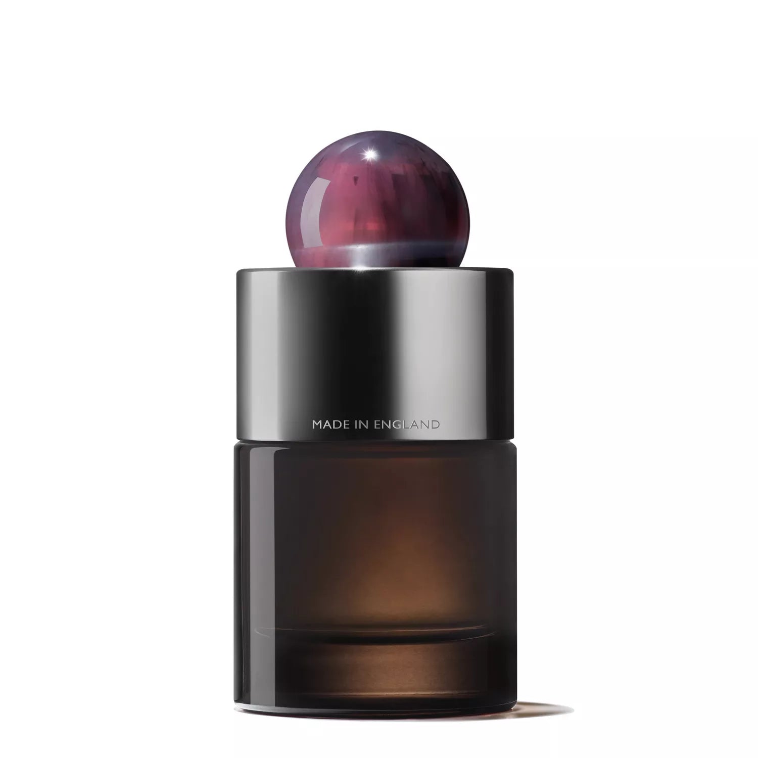 The MoltonBrown Nederlands Fiery Pink Pepper Eau de Parfum 100ml features a sleek, dark glass bottle with a metallic silver collar engraved "MADE IN ENGLAND" and a round, purple marbled cap, set against a plain white background.