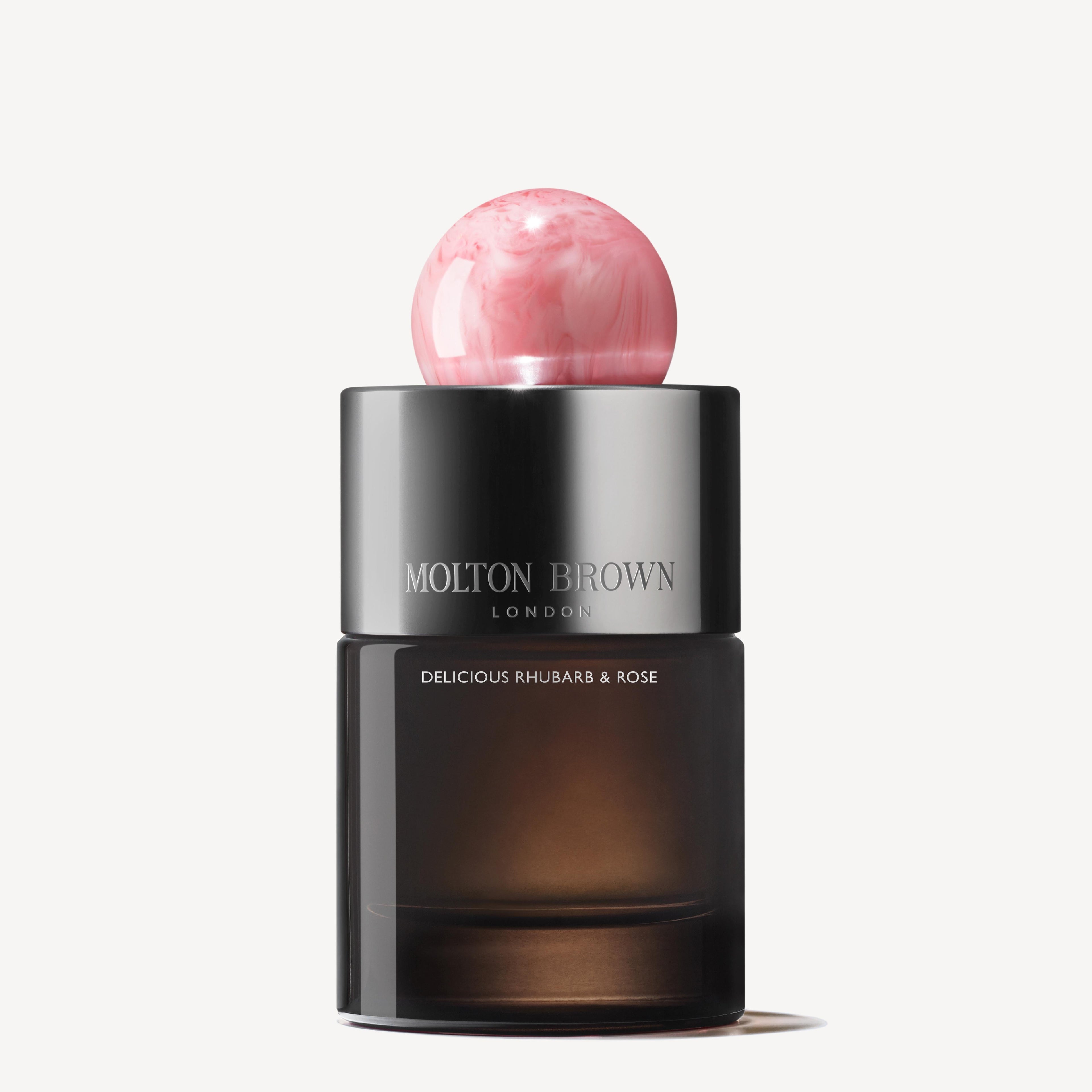 A 100ml bottle of MoltonBrown Nederlands Delicious Rhubarb & Rose Eau de Parfum features a round pink marbled cap, dark semi-transparent base, and jasmijn notes, shown against a white background.