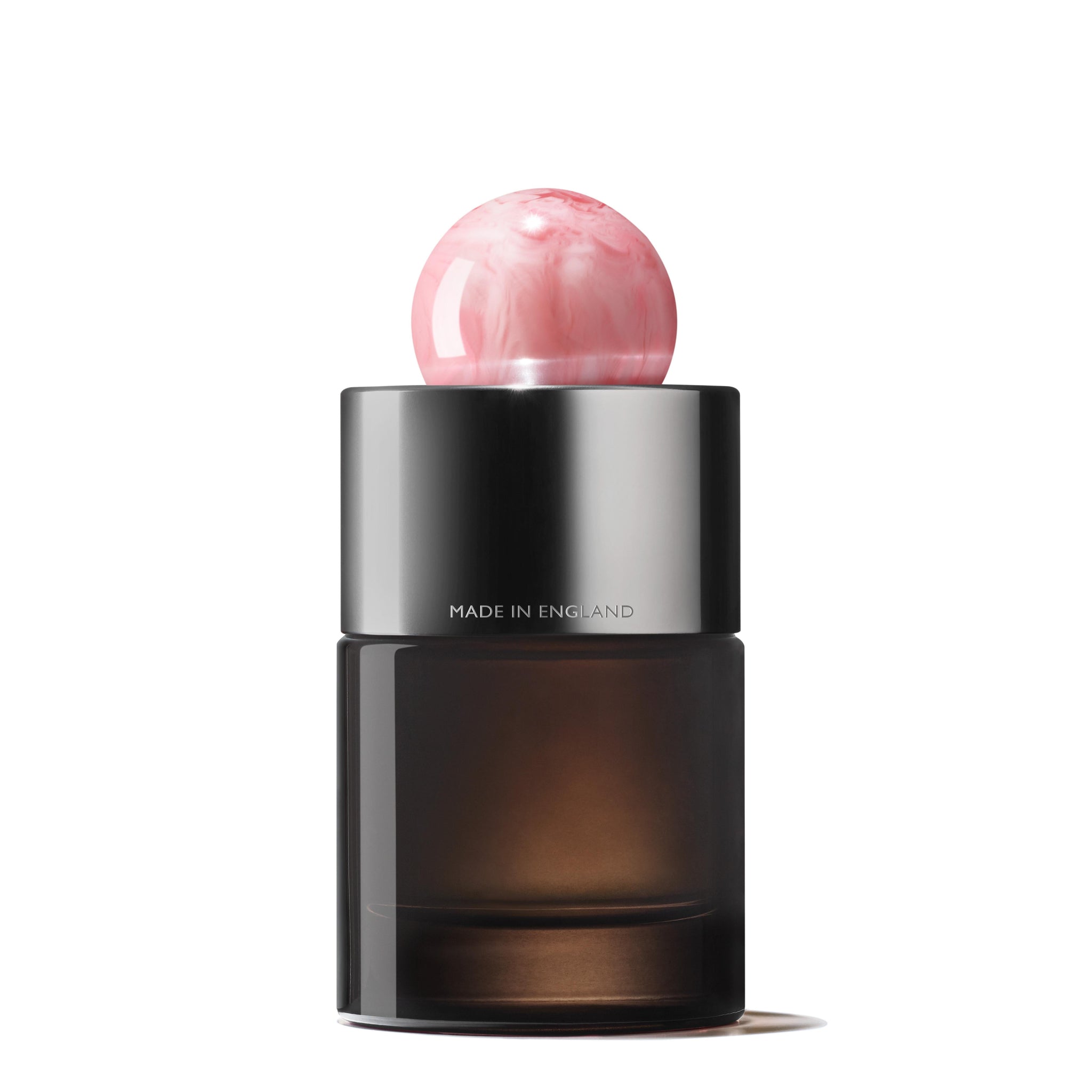 MoltonBrown Nederlands Delicious Rhubarb & Rose Eau de Parfum 100ml comes in a sleek dark glass bottle with a metallic silver collar marked "MADE IN ENGLAND" and a pink marbled cap. Contains jasmijn and witte moerbei extract. White backdrop.