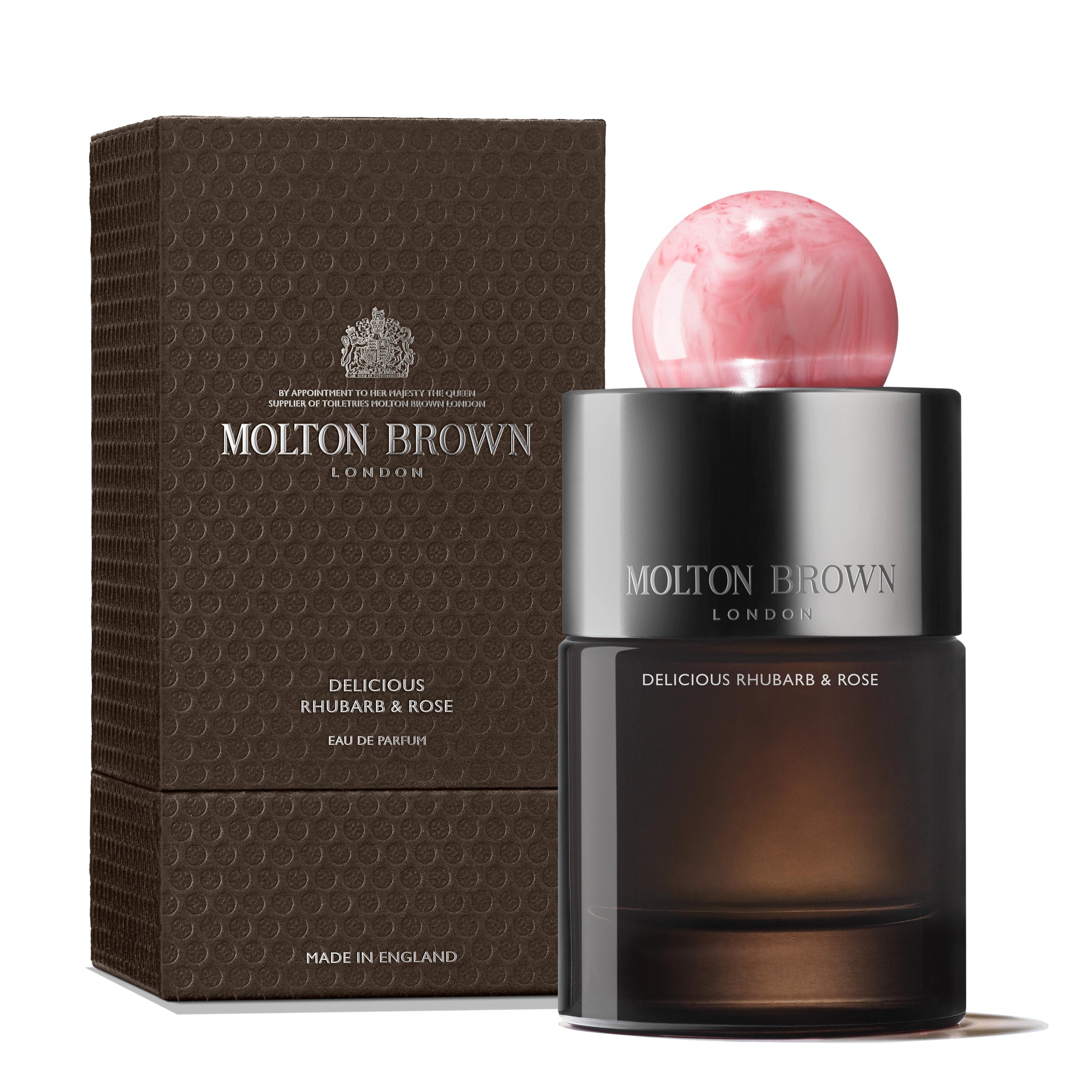 MoltonBrown Nederlands Delicious Rhubarb & Rose Eau de Parfum 100ml is shown with a pink marbled cap beside its textured brown box, both featuring silver and white details inspired by jasmijn and enriched with witte moerbei extract.