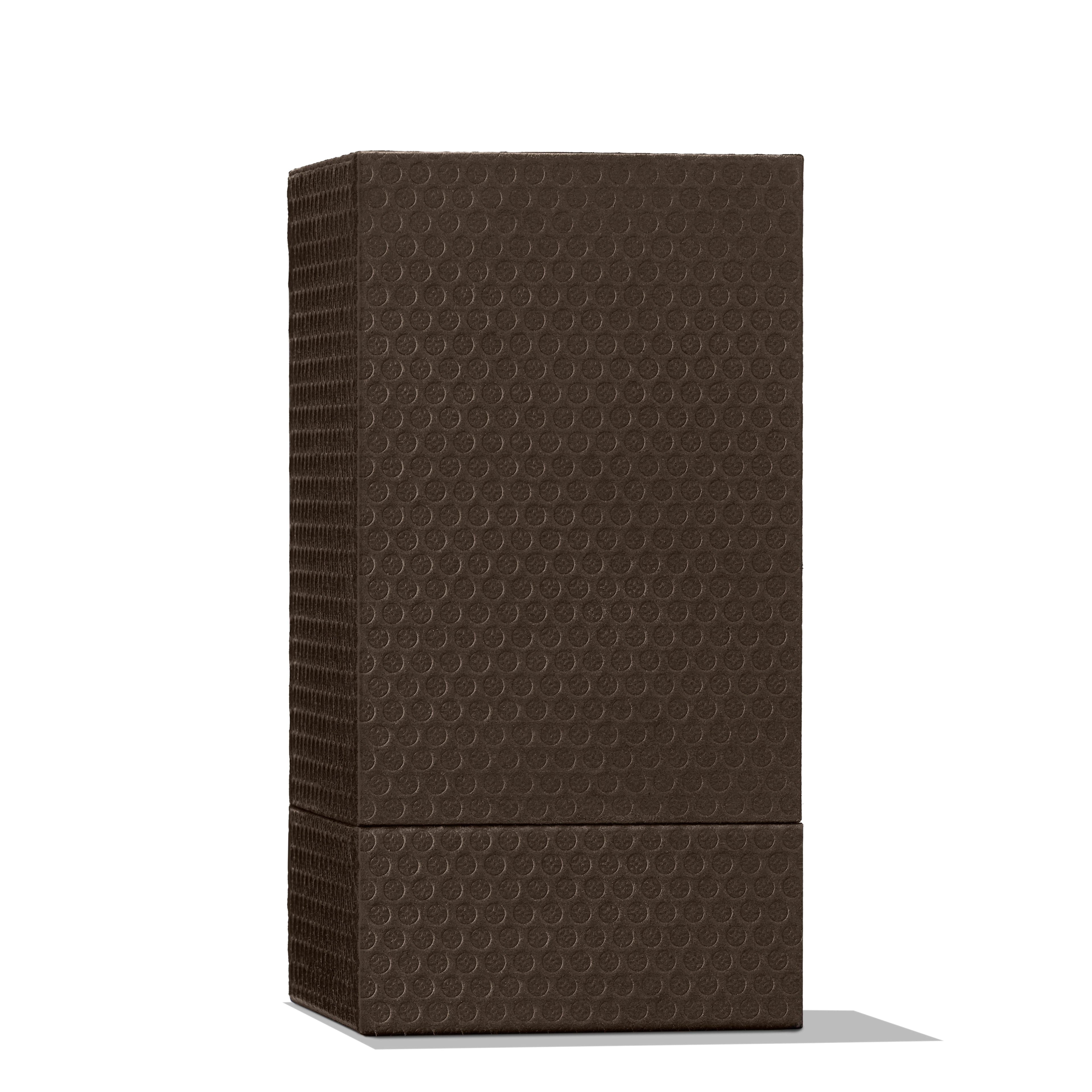 A tall, rectangular dark brown box with a subtle circular pattern stands upright against a white background, suggesting the refined scent of Delicious Rhubarb & Rose Eau de Parfum 100ml by MoltonBrown Nederlands within.