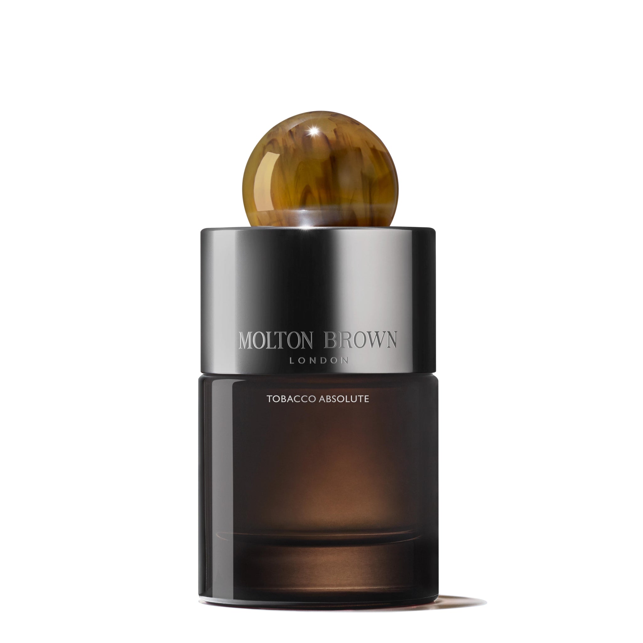 A 100ml bottle of MoltonBrown Nederlands Tobacco Absolute Eau de Parfum with a dark, semi-transparent base, metallic middle, and round, marbled brown cap.