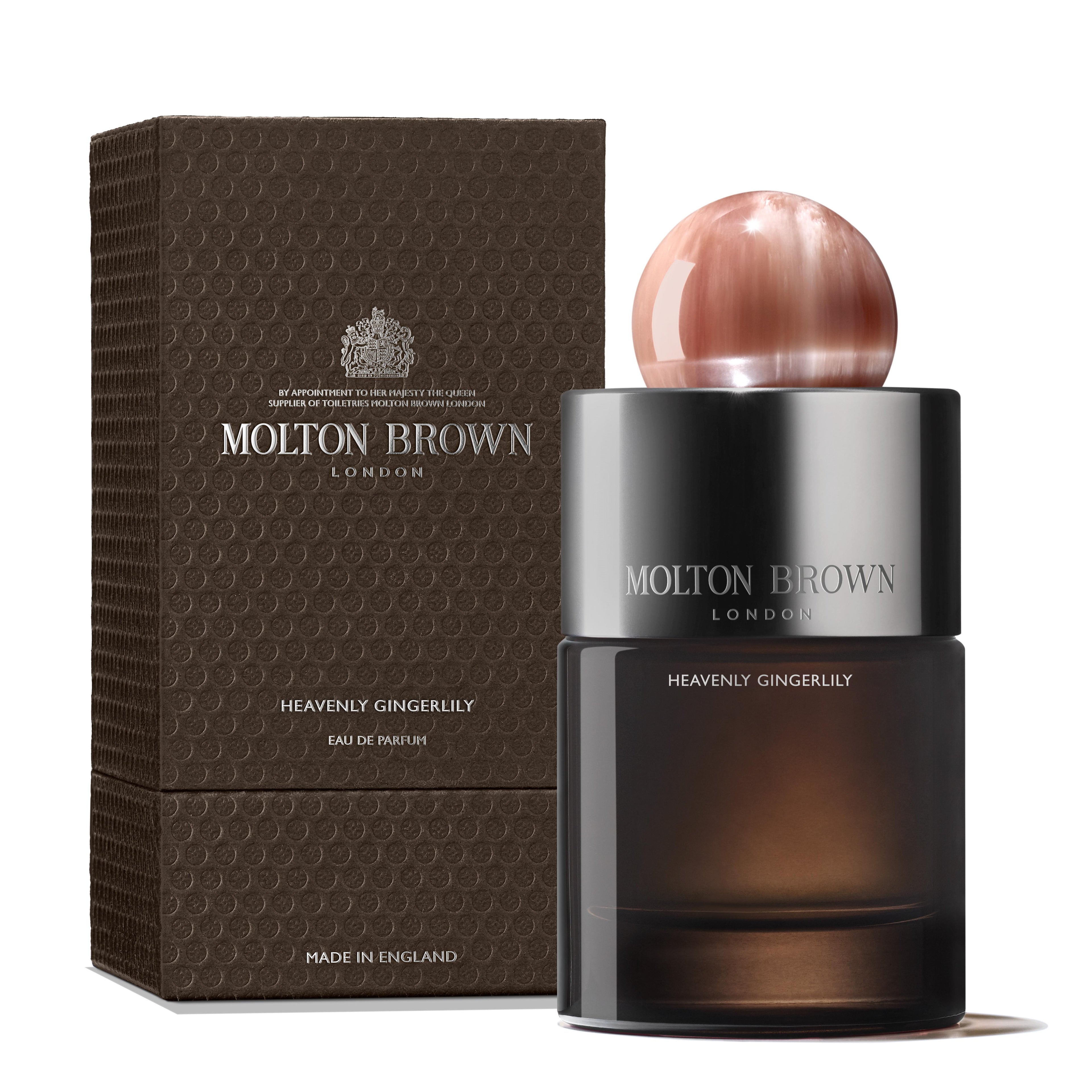 A MoltonBrown Nederlands Heavenly Gingerlily Eau de Parfum 100ml with a round pink cap stands by its textured brown box, both featuring silver branding on the hervulbare glazen flacon of this bloemig parfum.