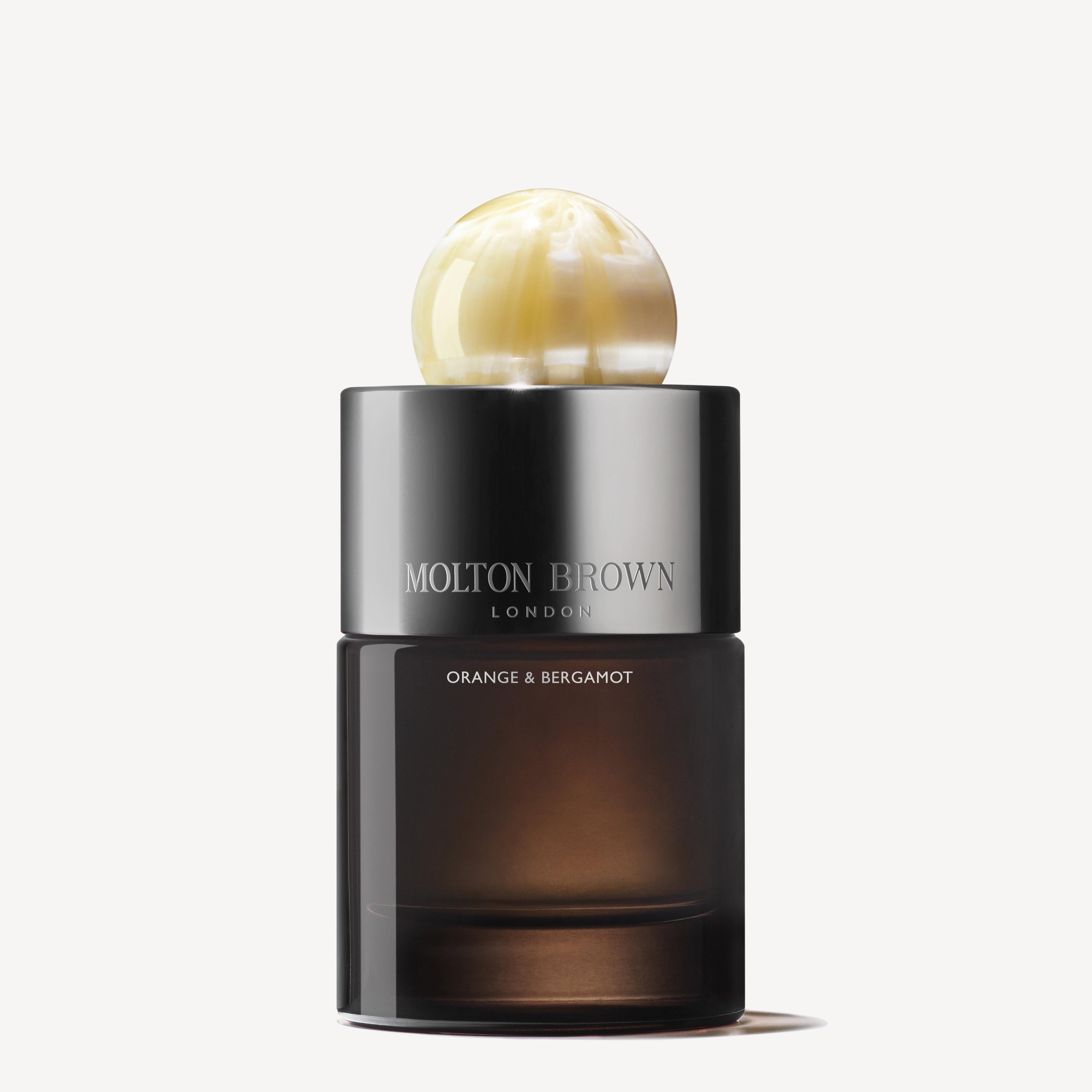 MoltonBrown Nederlands Orange & Bergamot Eau de Parfum 100ml features a dark, translucent base with silver branding and a marbled gold-and-cream cap. Patchouli hints add depth to this refined fragrance.