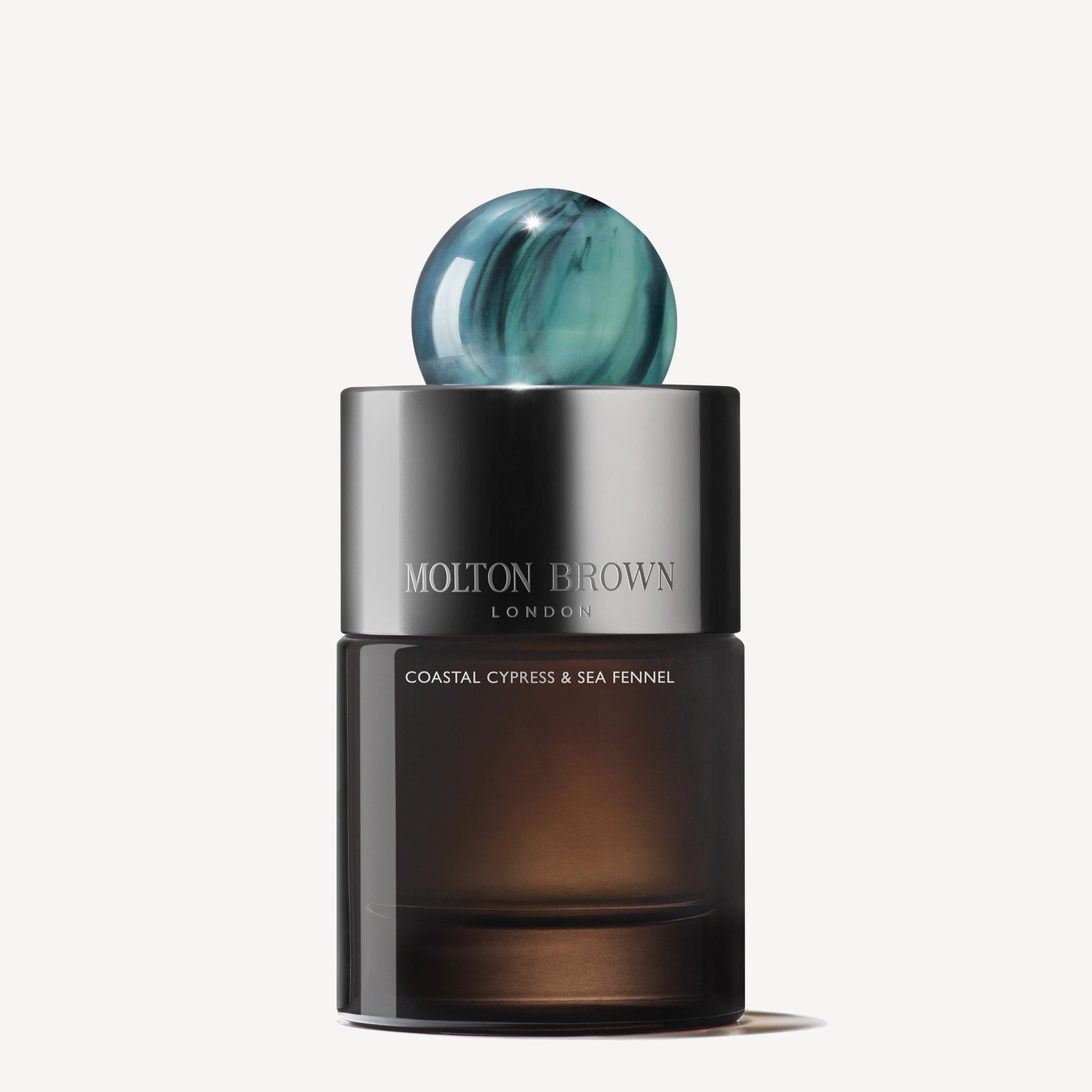 A MoltonBrown Nederlands Coastal Cypress & Sea Fennel Eau de Parfum 100ml bottle with a sleek dark base, silver label, and round blue marbled cap is set against a plain white background.