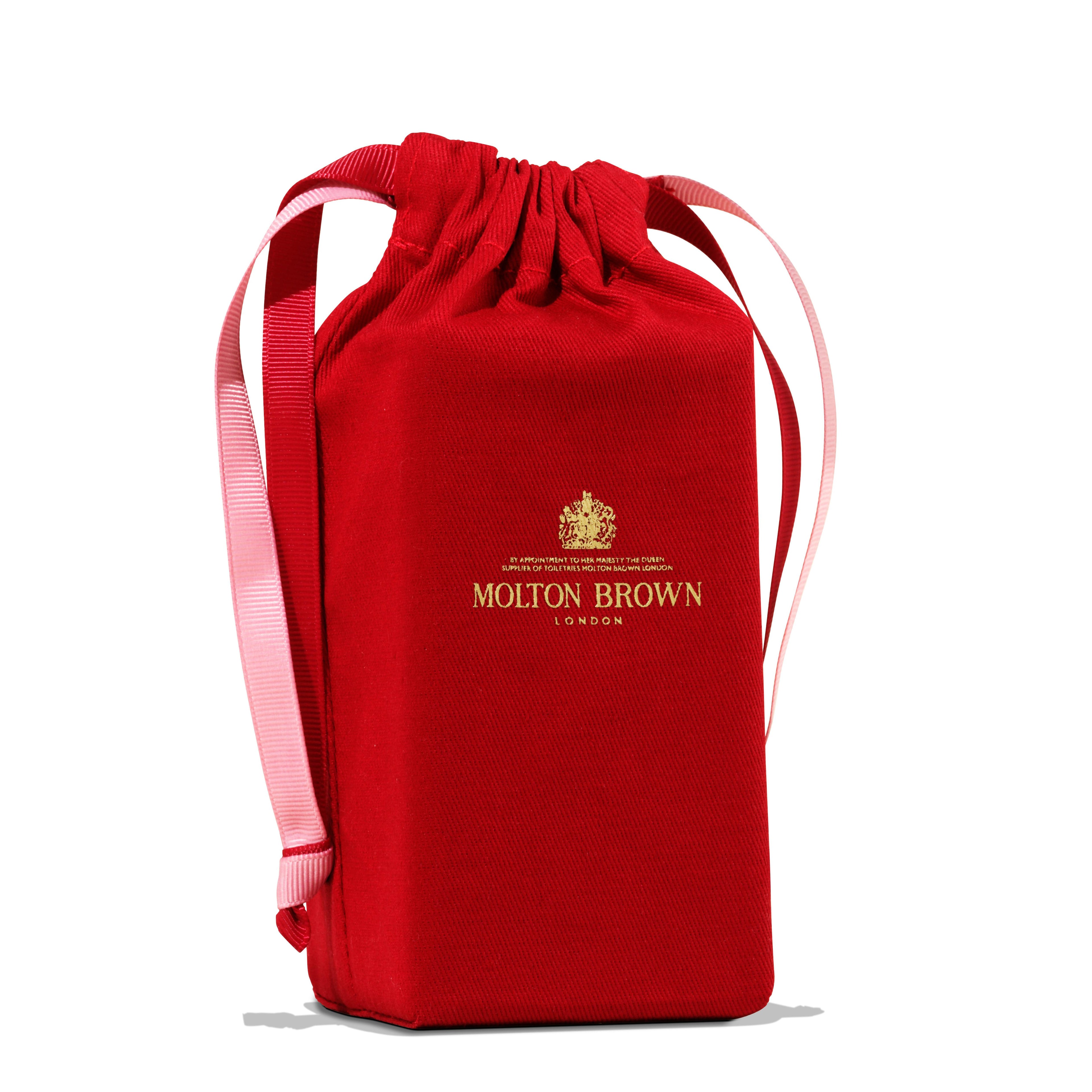 A red drawstring gift pouch with light pink handles and the MoltonBrown Nederlands gold logo, ideal for gifting the Milk Musk Eau de Parfum 100ml, is shown against a white background.