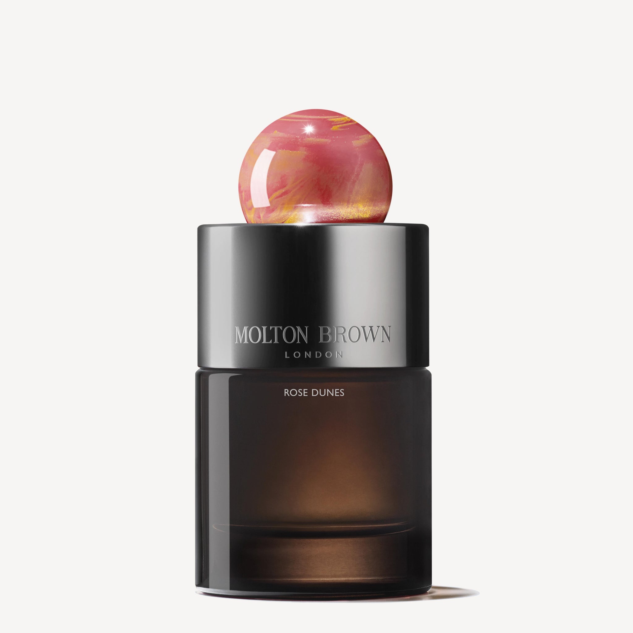 A 100ml MoltonBrown Nederlands Rose Dunes Eau de Parfum bottle, featuring a dark translucent base, sleek black cap, and round pink marbled stopper, set against a plain white background.