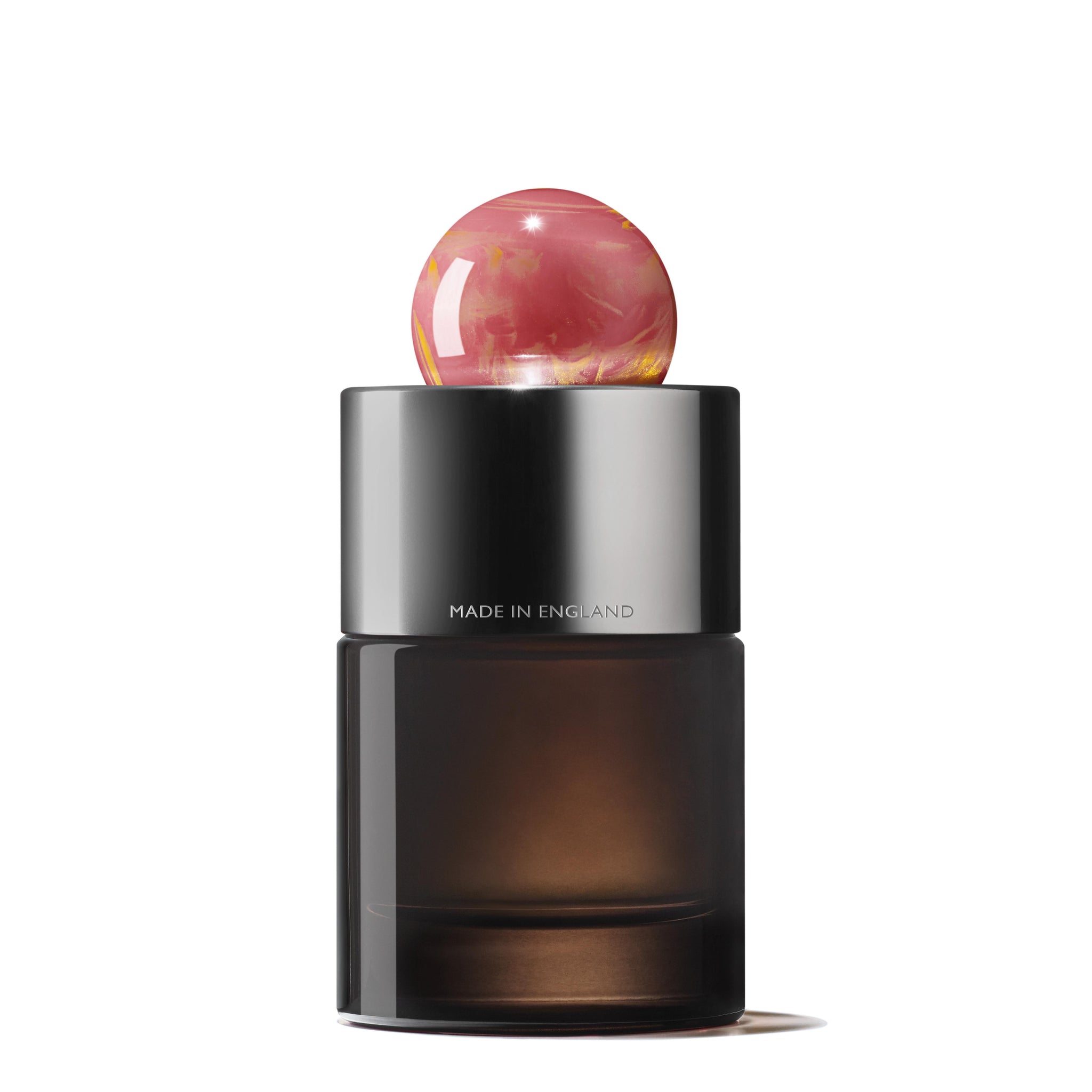 The Rose Dunes Eau de Parfum 100ml by MoltonBrown Nederlands features a dark glass bottle with a metallic silver collar inscribed "MADE IN ENGLAND" and a round, pink marbled cap. Its elegant design is inspired by hints of amber patchouli and set against a white background.