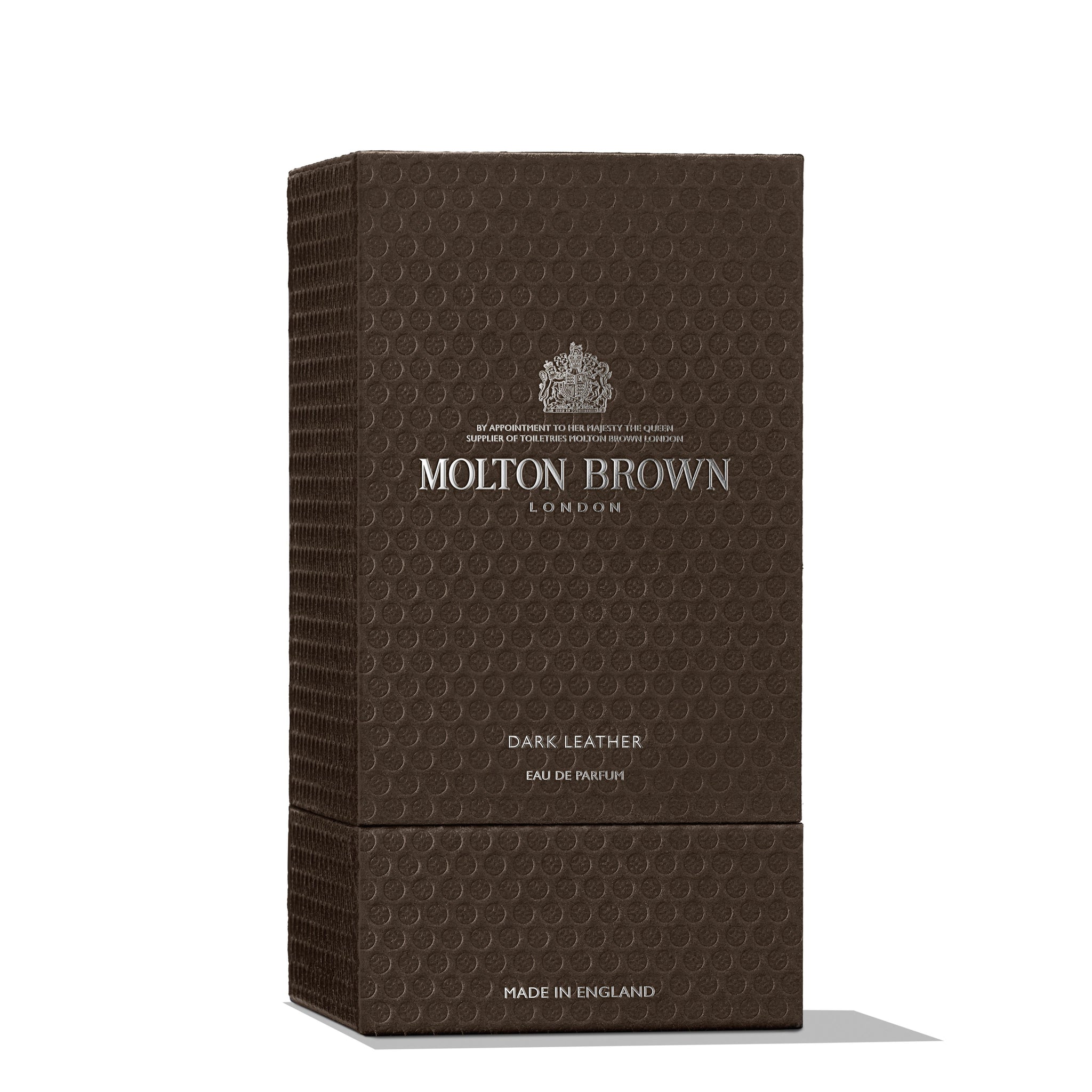 A rectangular, textured dark brown box from MoltonBrown Nederlands featuring "Dark Leather Eau de Parfum 100ml" in silver lettering. Hinting at musk notes, the package states "Made in England" at the bottom.