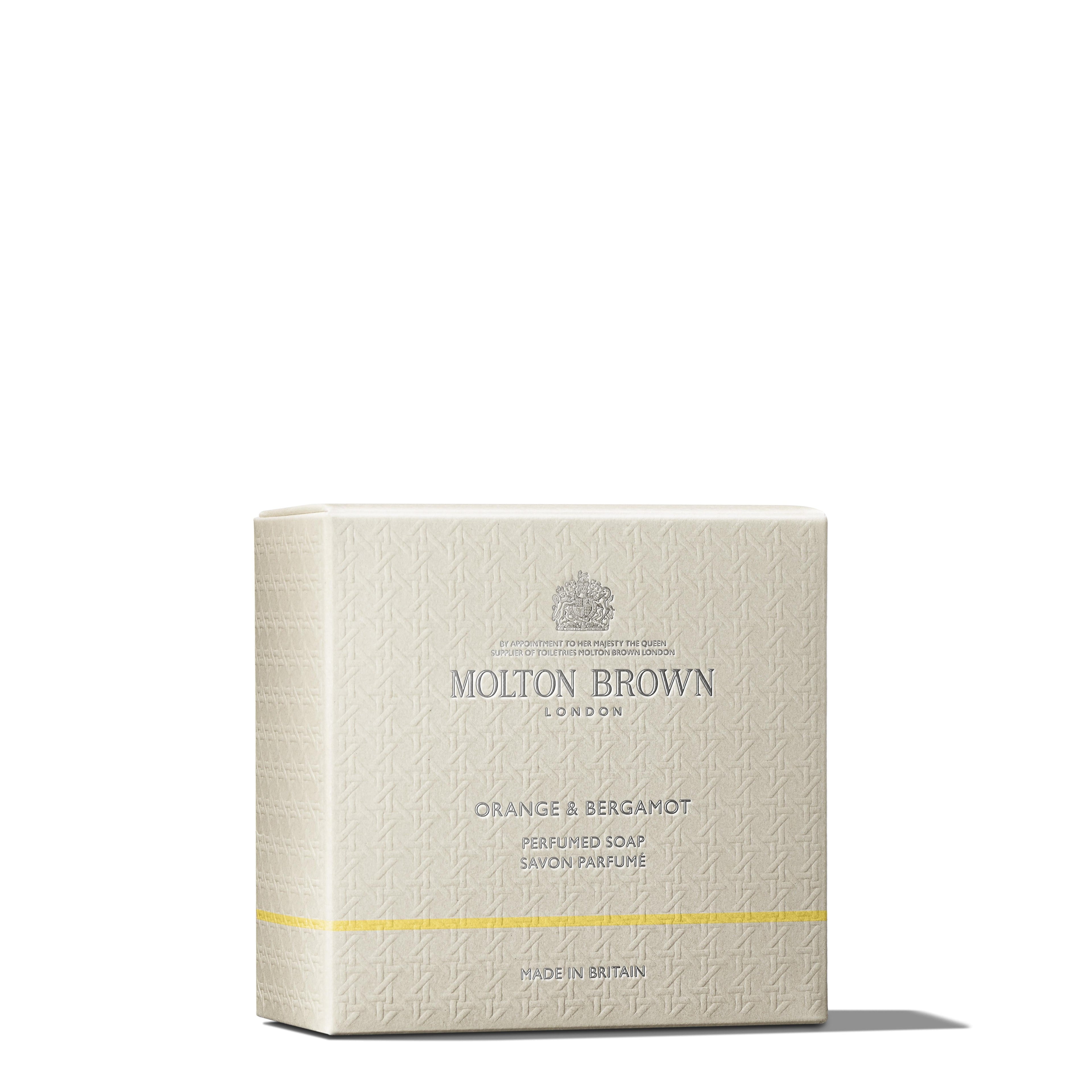 A beige box of MoltonBrown Nederlands Orange & Bergamot Perfumed Soap 150g, enriched with natuurlijke oliën, features textured patterns, silver text, and a thin yellow line near the bottom against a white background.