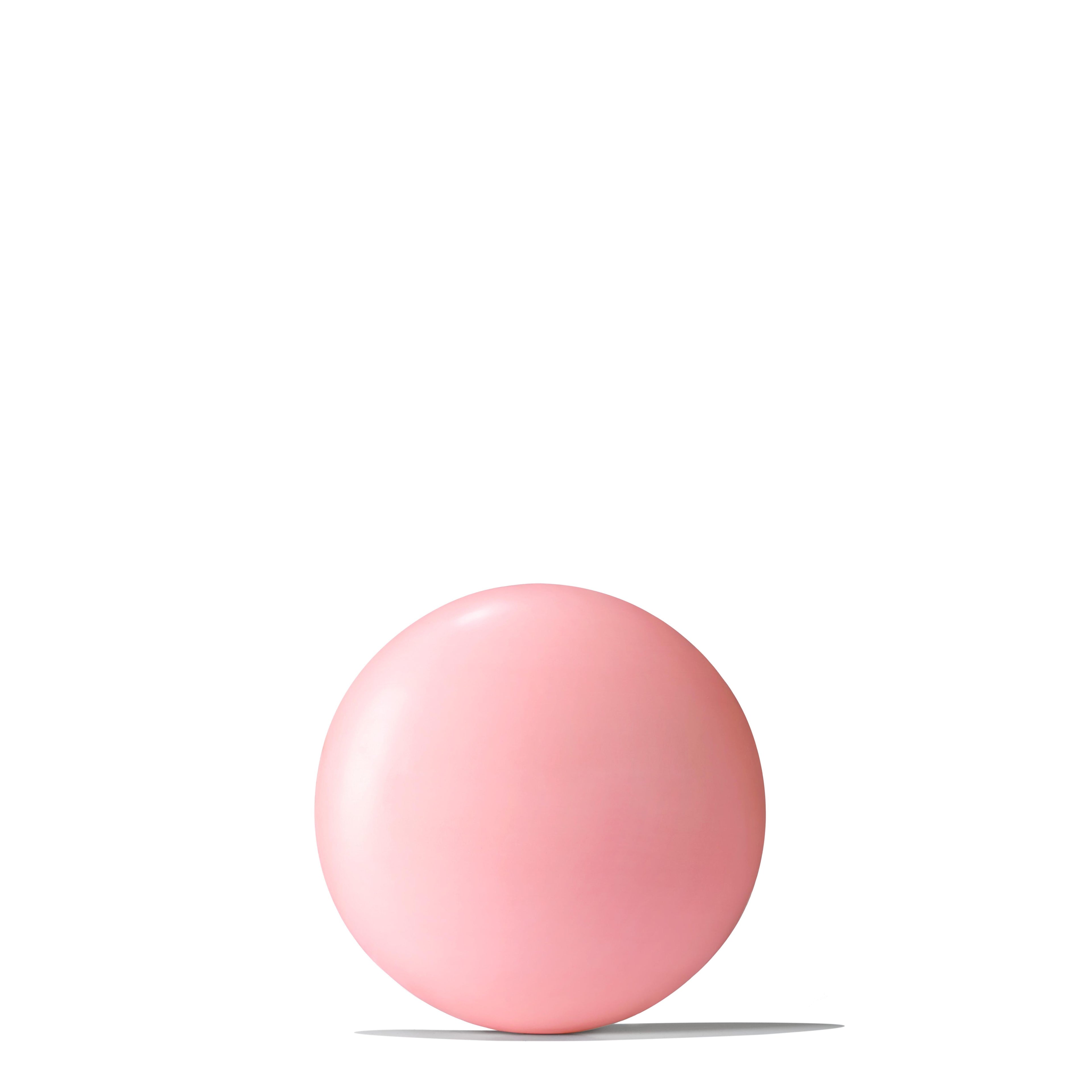 A single pink bubblegum ball rests on a white surface, its hue mirroring the delicate shade of MoltonBrown Nederlands Rose Dunes Bodylotion 300ml, with a soft shadow beneath and centered against a plain white background.