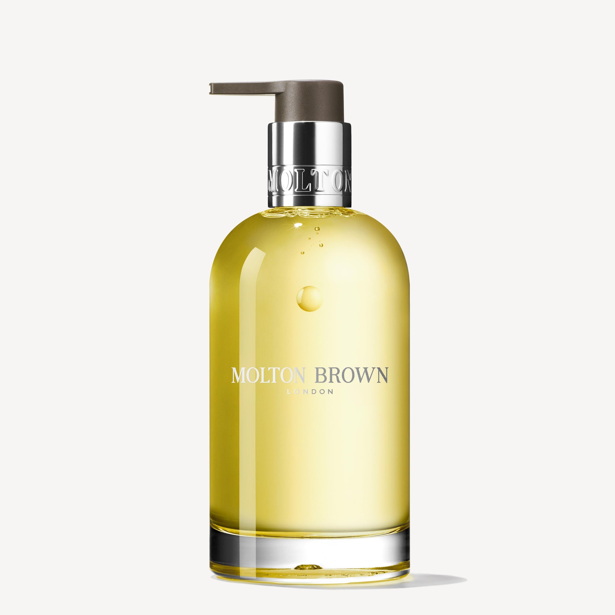 A clear glazen fles van MoltonBrown Nederlands Orange & Bergamot Vloeibare Handzeep 200ml met zilveren pomp, perfect voor een luxe badkamer, staat tegen een witte achtergrond.