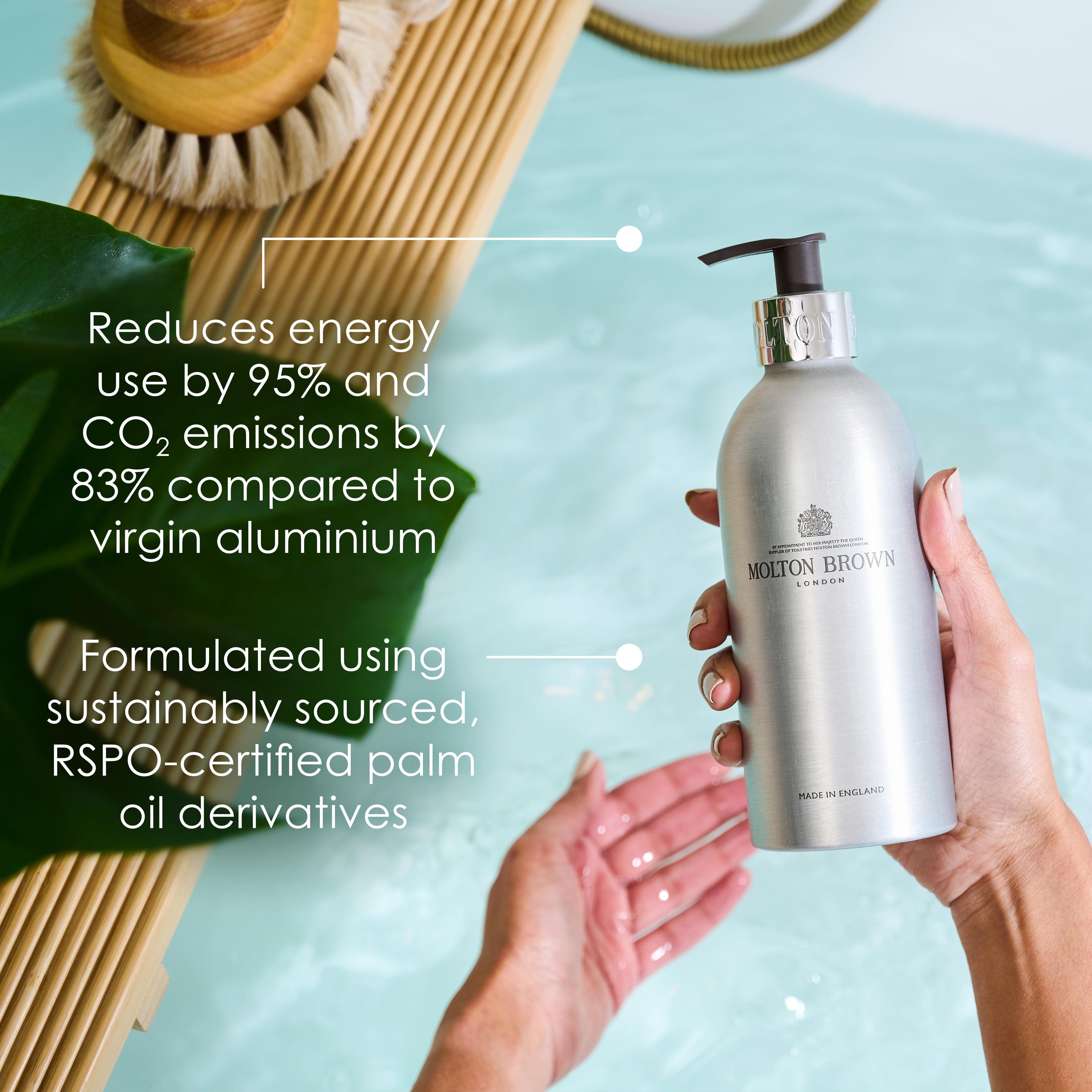 A person holds a MoltonBrown Nederlands Re-charge Black Pepper Navulbare Fles 400ml, made from gerecycled aluminium, above a bathtub with houten tray. Tekst benadrukt minder energieverbruik, lagere CO₂-uitstoot en duurzaam verkregen palmolie-derivaten.